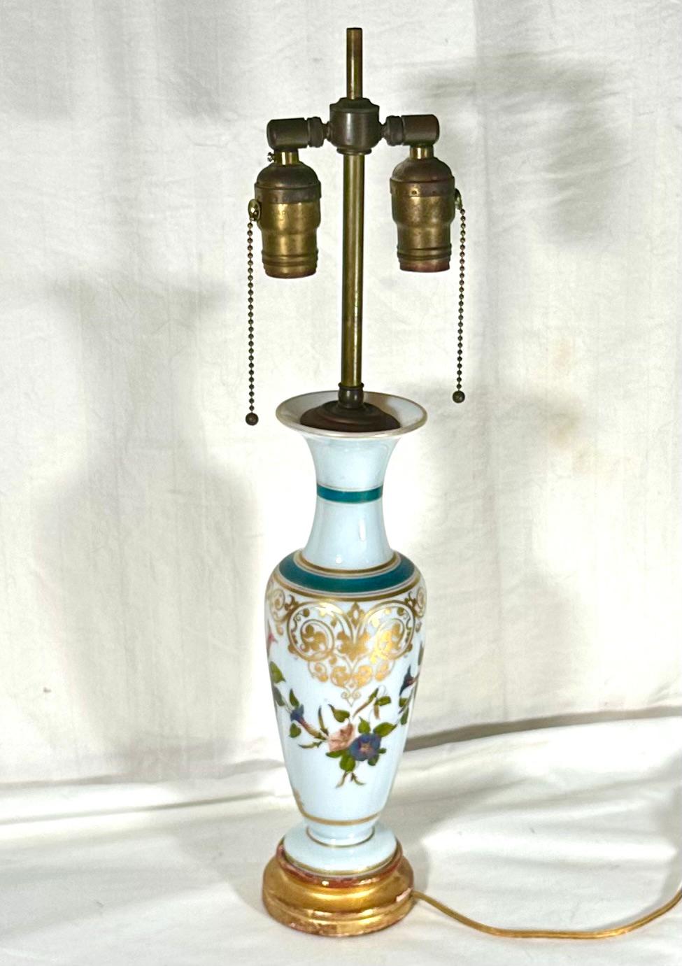 Vase-lampe français en verre opalin blanc Attribué à Baccarat.

Magnifique vase de forme balustre en verre opalin blanc décoré de guirlandes de fleurs colorées. L'épaule est ornée d'arabesques dorées. Le vase est transformé en lampe et est monté sur