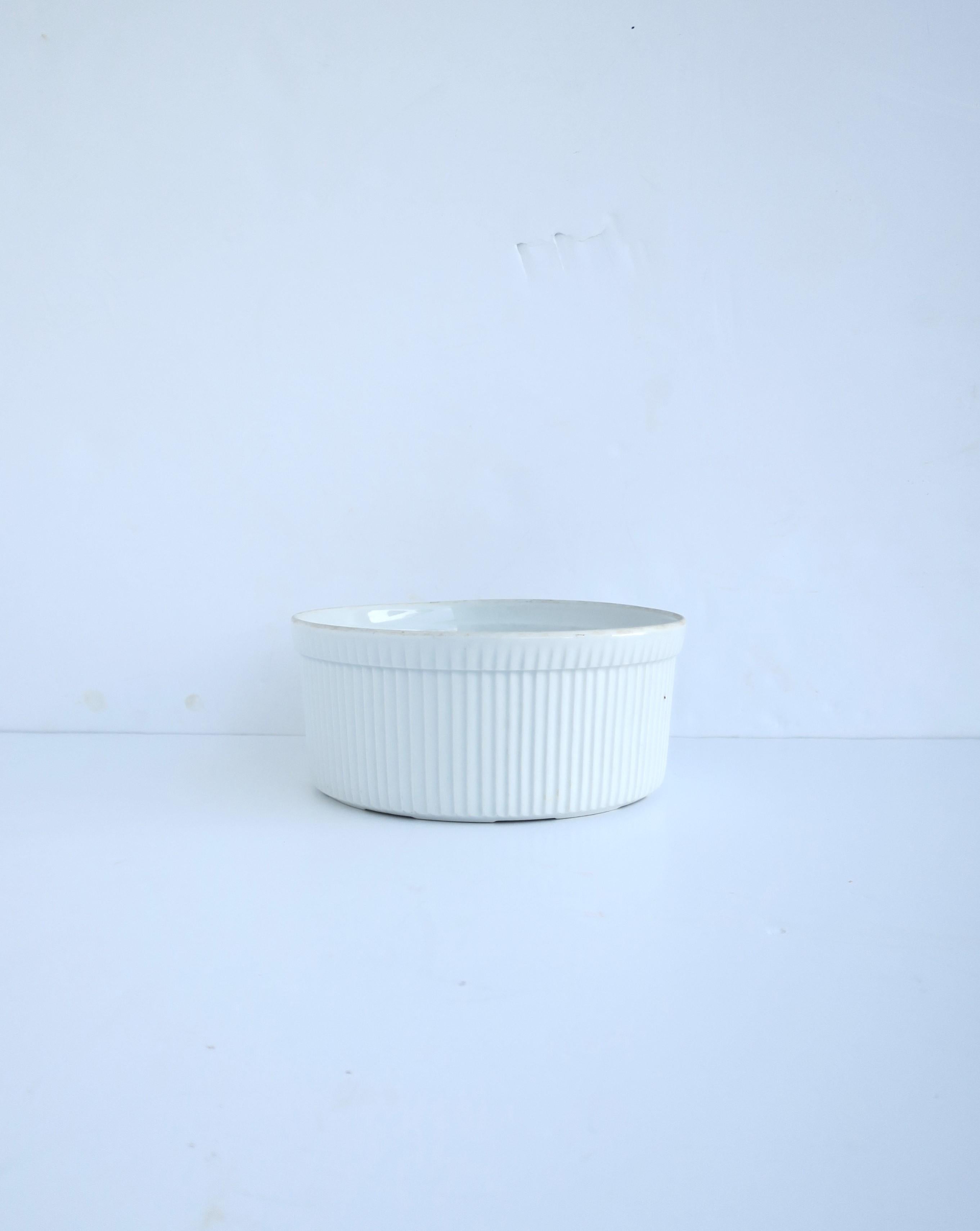 A French white porcelain bowl with fluted design, circa mid-20th century, France. A simple white porcelain souffle' or serving bowl with fluted design around exterior. Great for serving or cooking/baking. Made in France as marked on underside, shown
