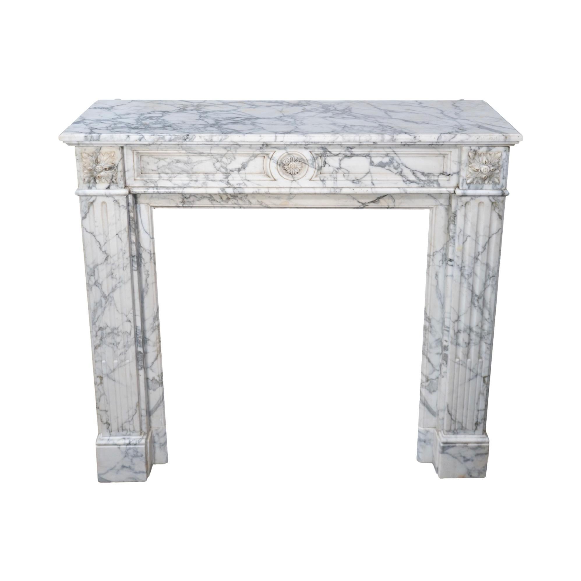 Expertly crafted from luxurious French White Veined Carrara Marble, this mantel exudes elegance and sophistication. With intricate carved floral motifs and bolection style carvings, it is a stunning representation of the Louis XVI style. Dating back