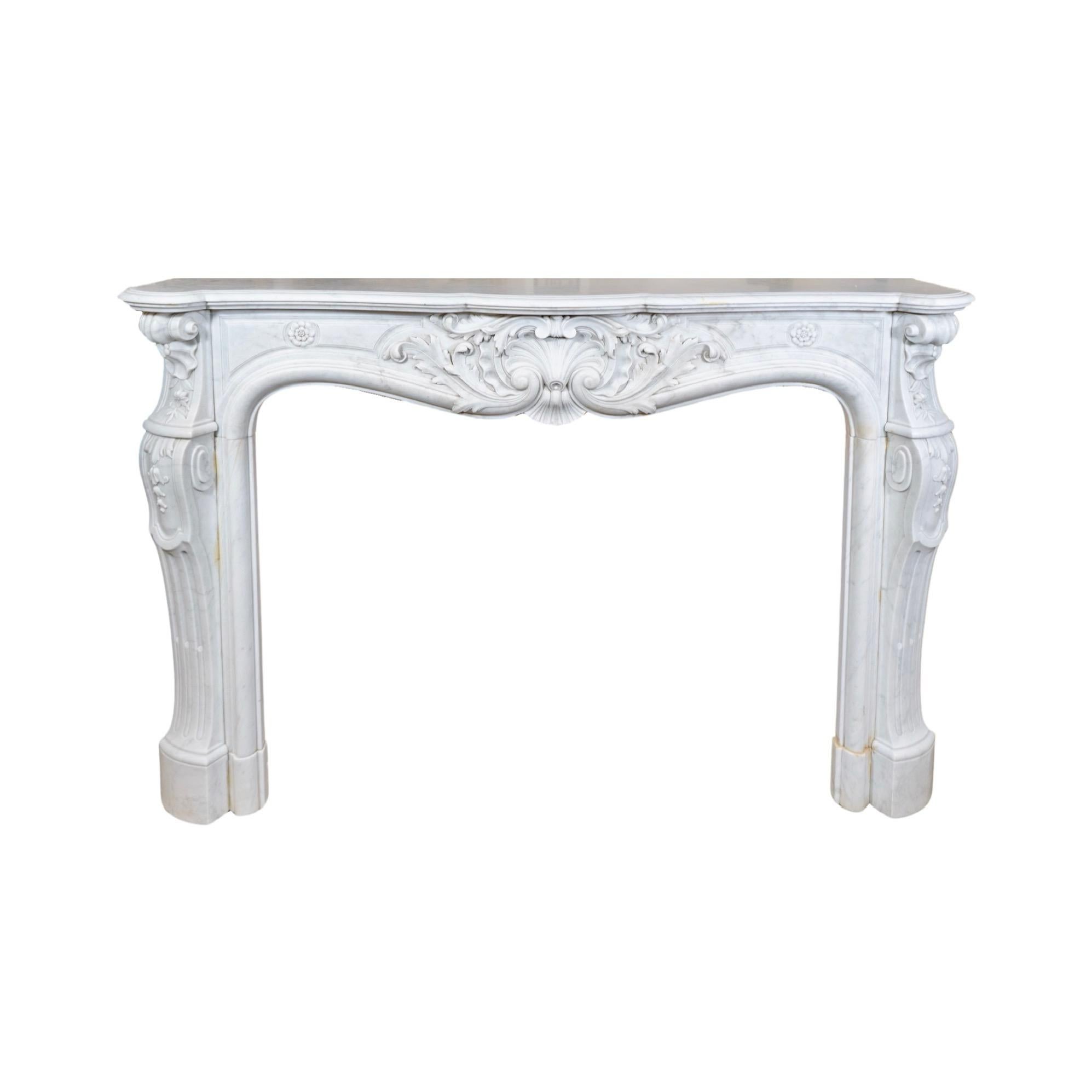 This 1870s French White Veined Carrara Marble Mantel exudes elegance and sophistication. The intricate floral carvings found throughout the legs and center add a touch of luxury to any room. Crafted from the highest quality marble, this mantel from