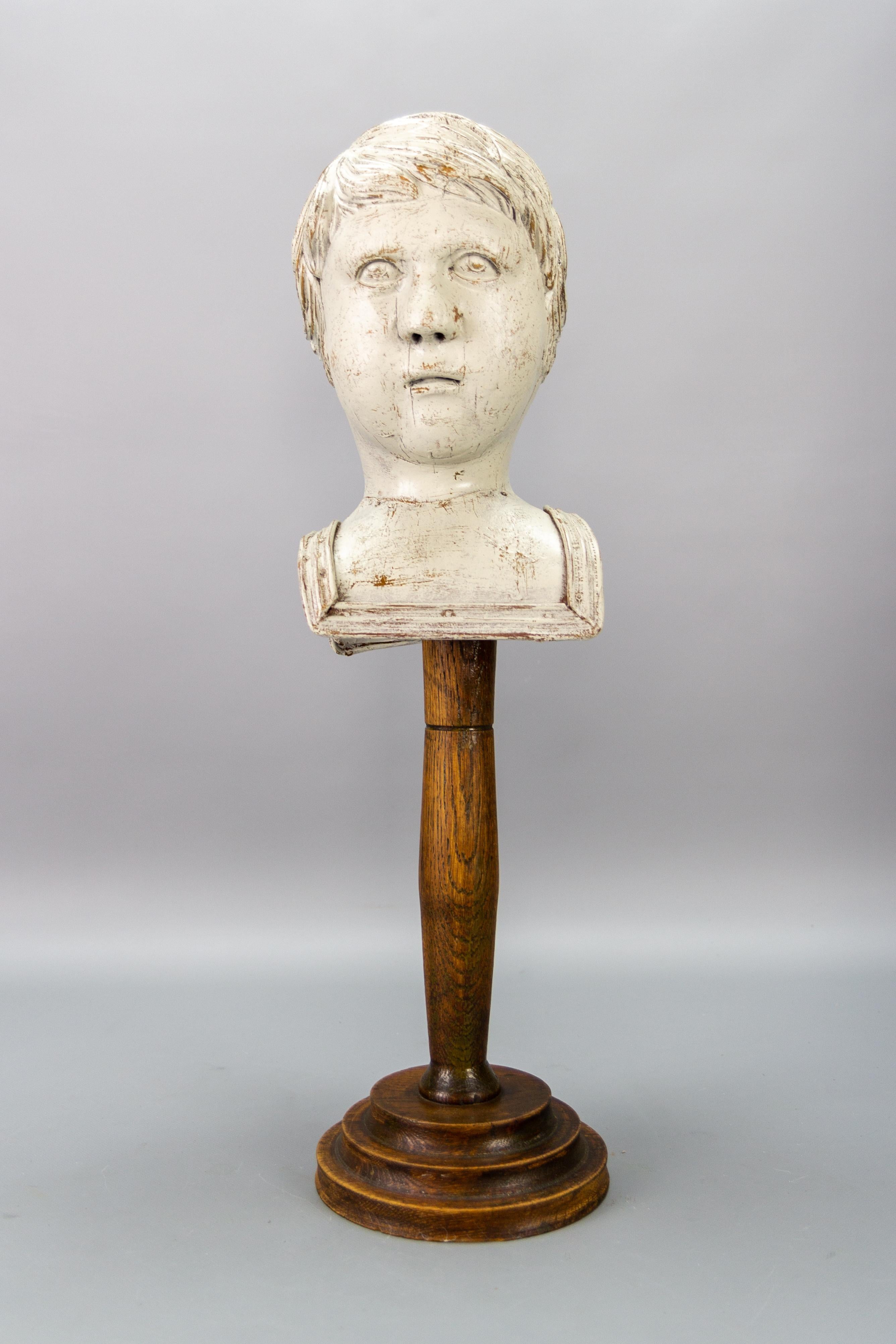 Whitewashed carved wooden sculpture head or bust on a dark brown pedestal, France, circa the 1920s.
This adorable decor - a sculpture of a boy's or angel's head or bust has been carved of oakwood and whitewashed. The pedestal was made in 1920