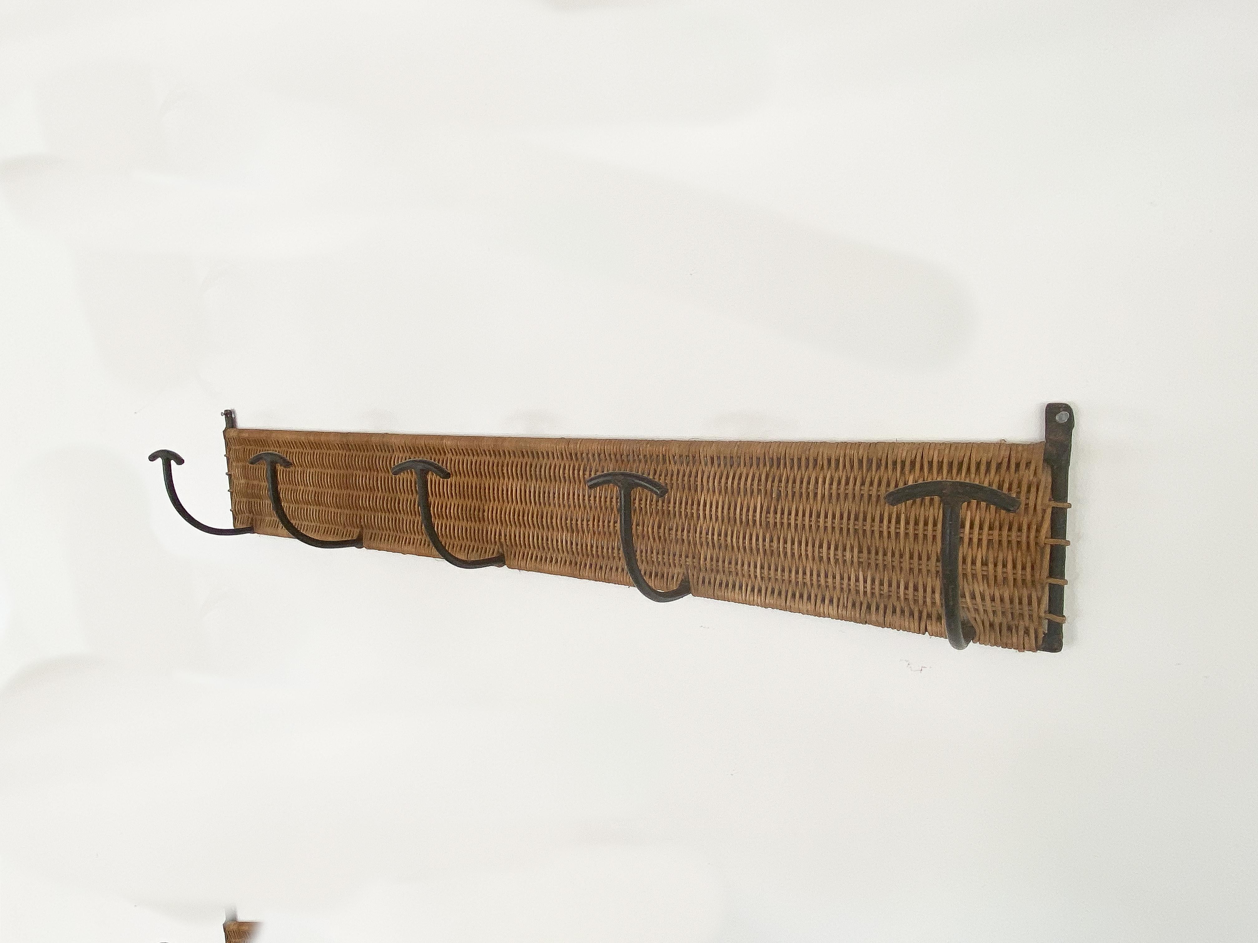 Vintage French woven wicker coat rack with 5 iron hooks to hand coats or hats. Black painted iron is original with chips in paint and signs of wear. Beautiful and functional piece.