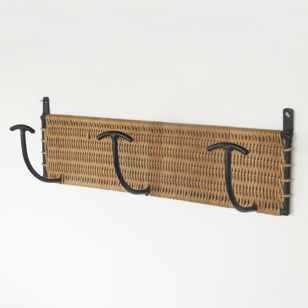 Vintage woven wicker wall rack with 3 iron hooks to hang coats or hats. Black painted iron and wicker is all original. Beautiful and functional piece from France, 1950s.