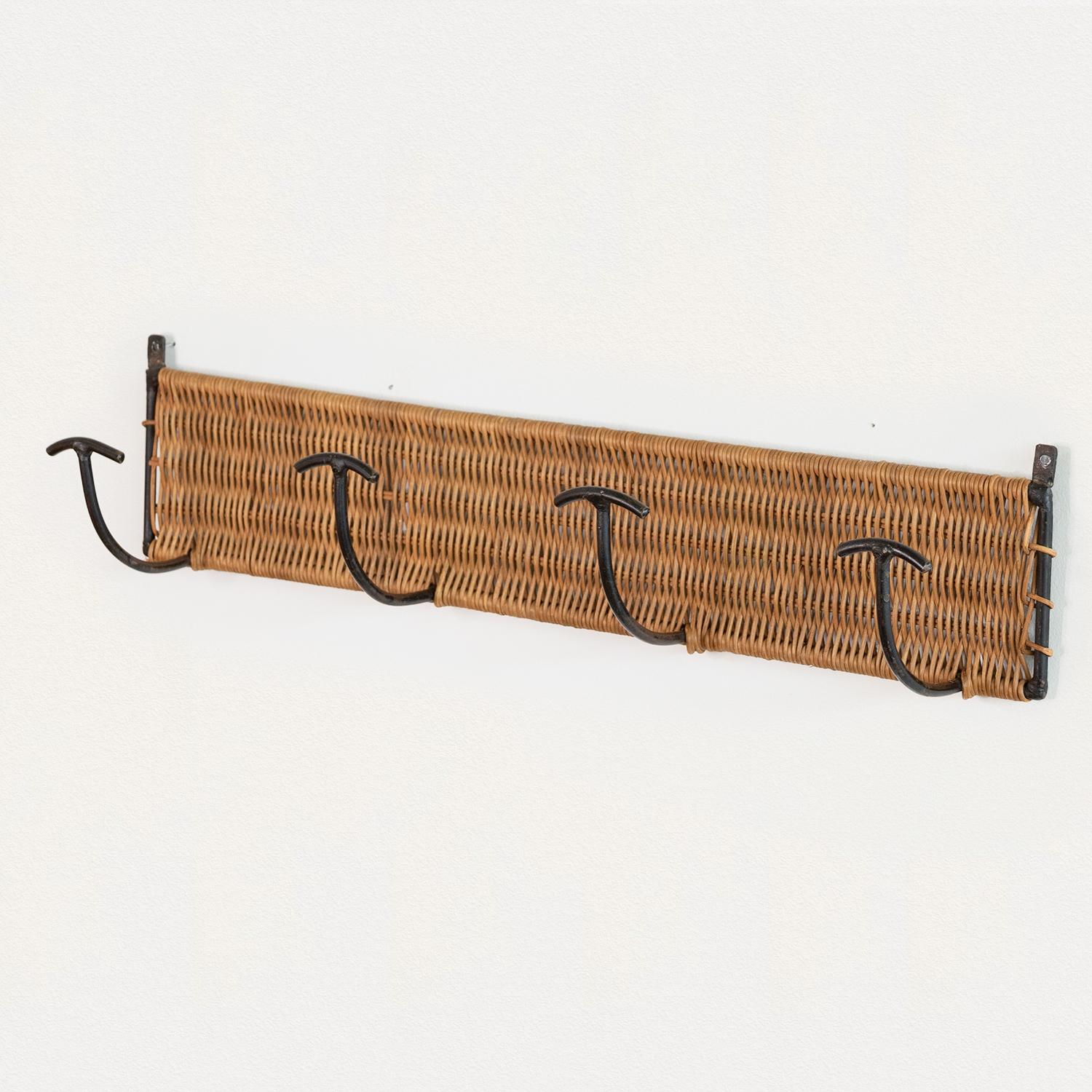 Vintage woven wicker wall rack with 4 iron hooks to hang coats or hats. Black painted iron and wicker is all original. Beautiful and functional piece from France, 1950s.