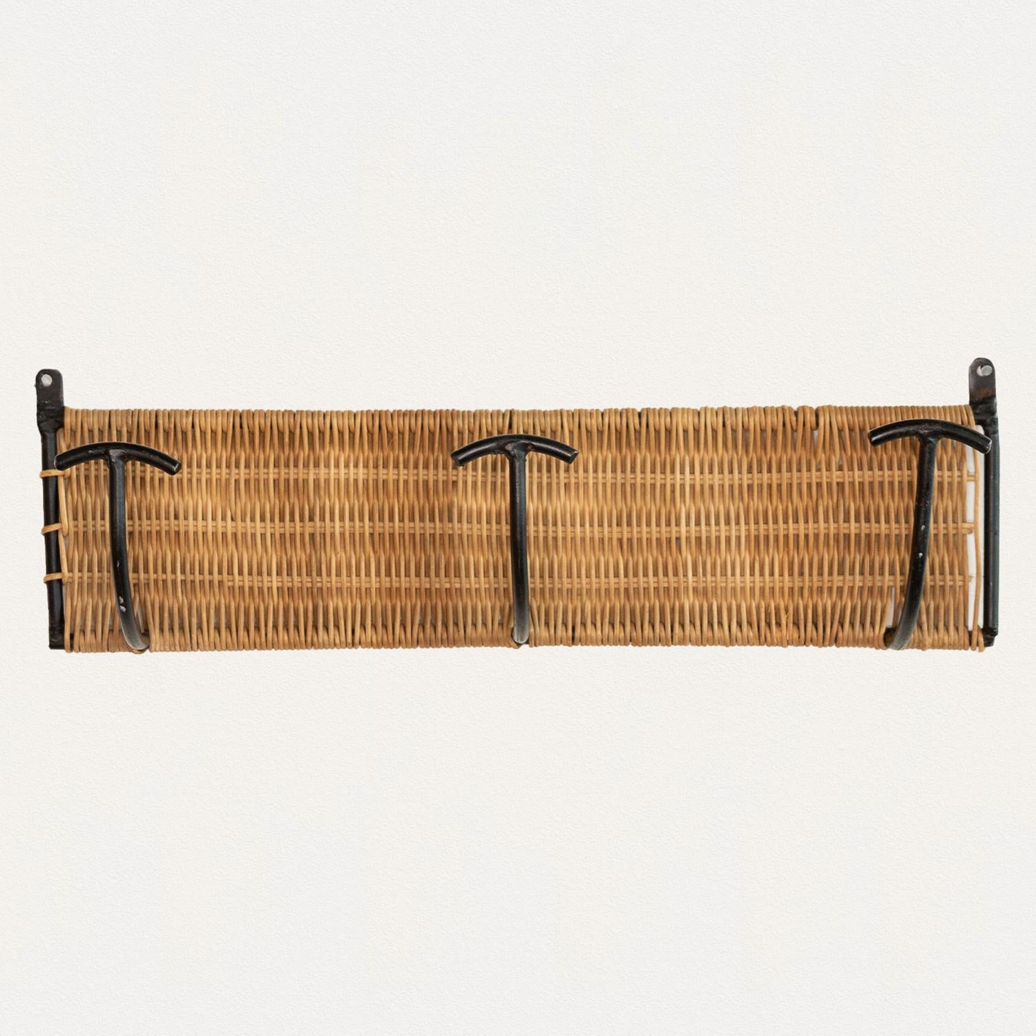 Vintage woven wicker wall rack with 3 iron hooks to hang coats or hats. Black painted iron and wicker is all original. Beautiful and functional piece from France, 1950s. Three available.