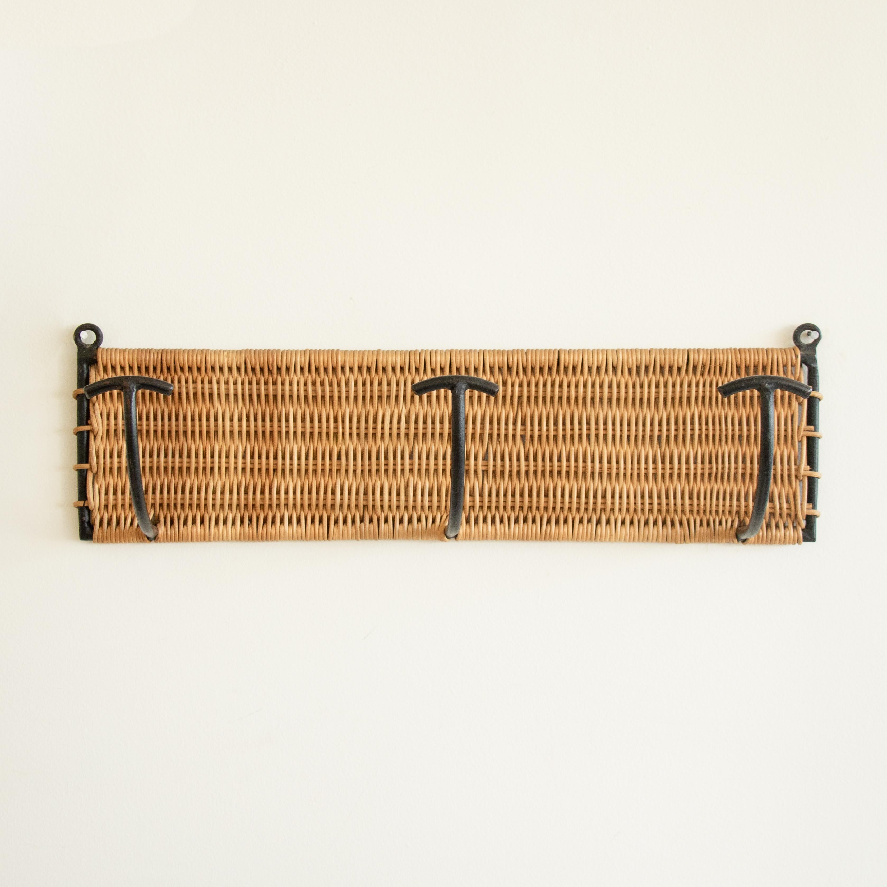 Vintage woven wicker wall rack with 3 iron hooks to hang coats or hats. Black painted iron and wicker is all original. Beautiful and functional piece from France, 1950s. Three available, sold individually. 