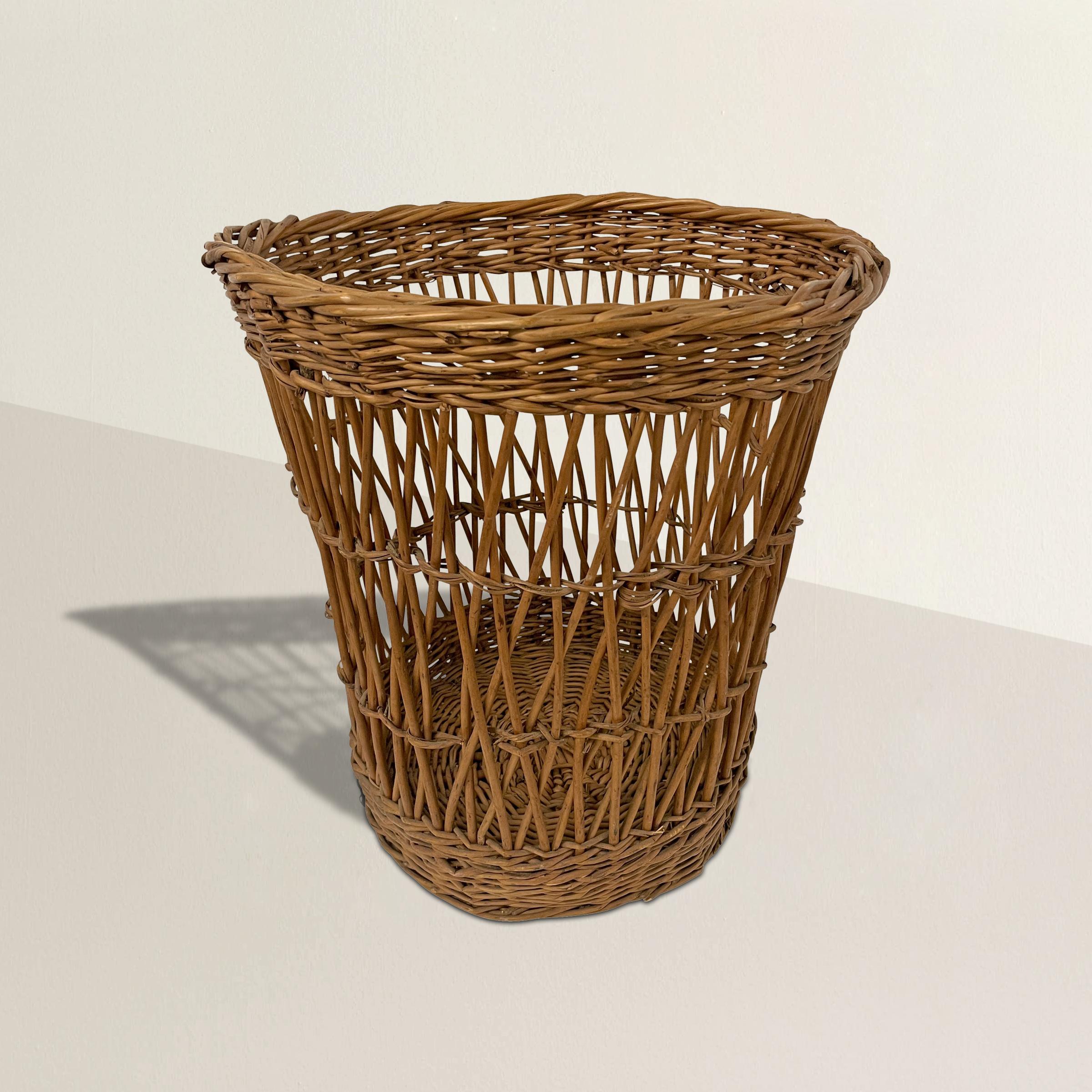 A wonderful 20th century French woven wicker basket originally used in a bakery to hold baguettes or other loaves of bread, but if you don't have a bakery in your house, it's perfect for use as a wastepaper basket in your office or powder room.