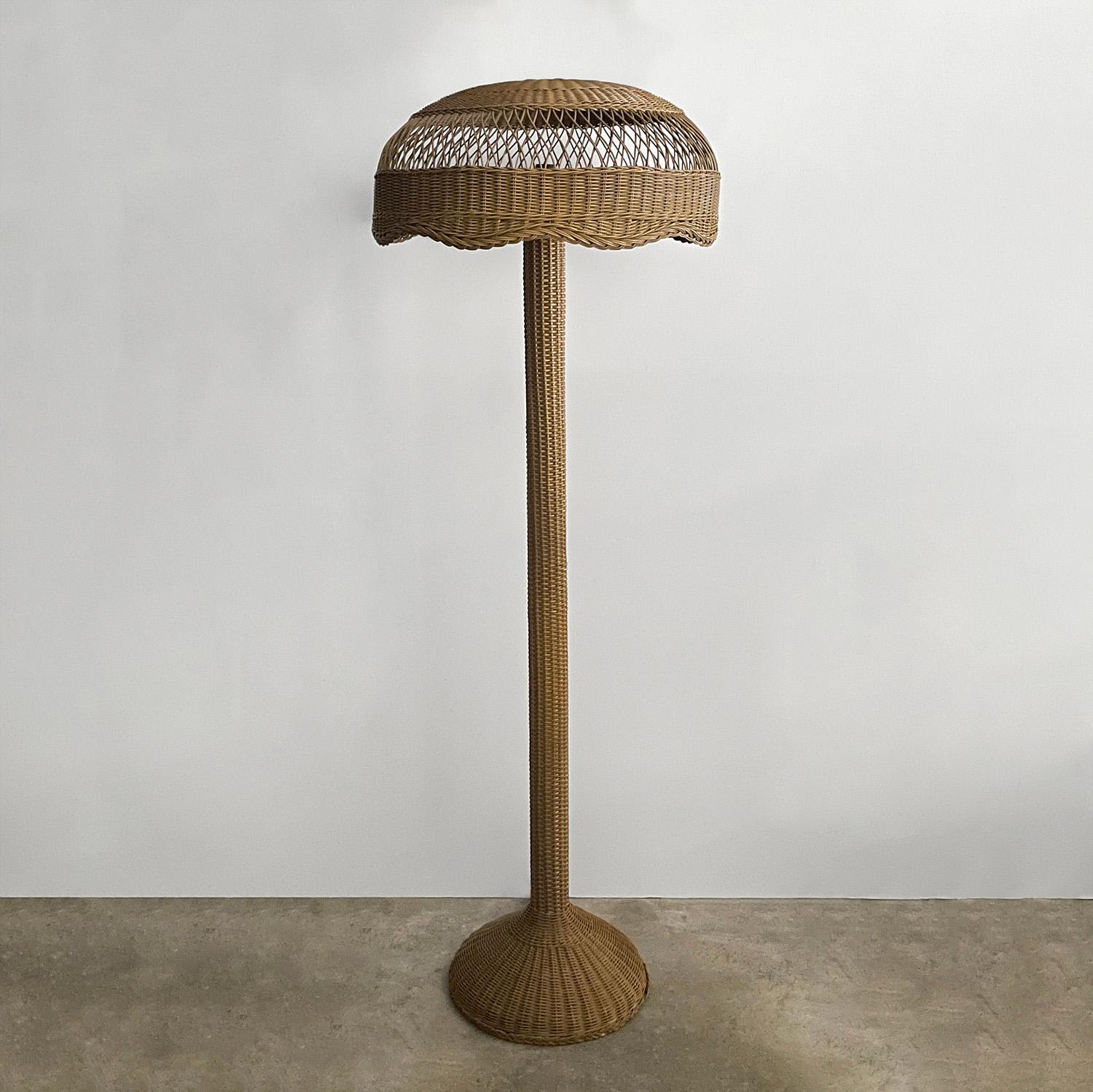 French wicker floor lamp
France, mid century 
Intricately woven wicker encompasses the lamp frame 
Shade has a lovely scalloped edge detail and illuminates light beautifully 
Wicker has minor loss and imperfections 
Newly reconditioned 
Patina from