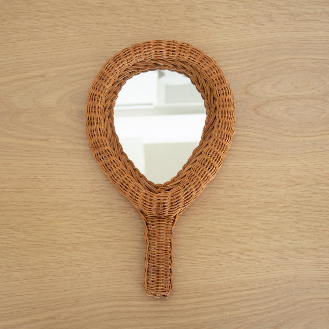Great vintage wicker hand-held vanity mirror from France. Teardrop shape wicker frame with handle and original glass mirror.