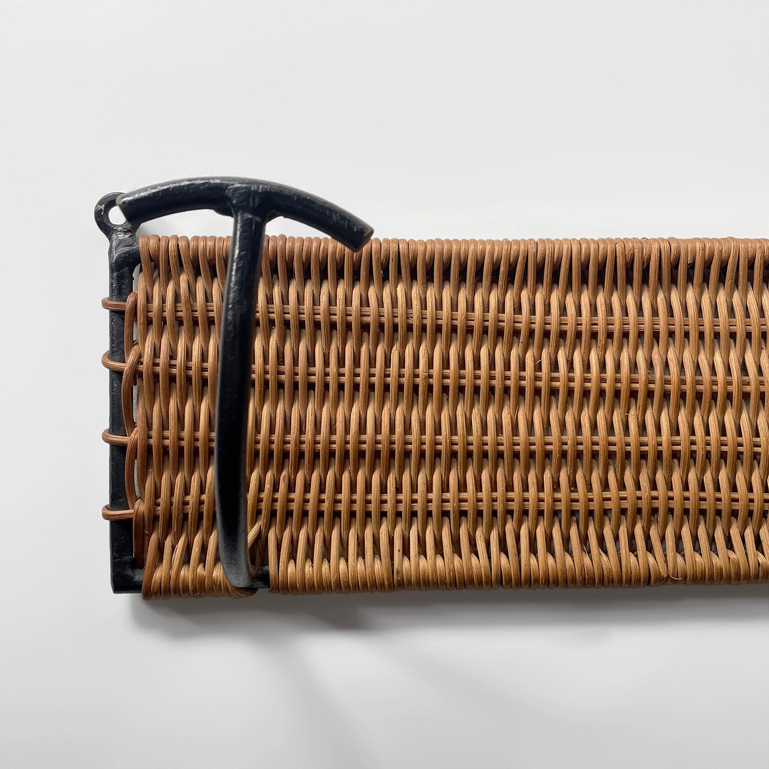 French wicker coat rack with 3 iron hooks
France, circa 1950s
Beautiful form and function
Intricately woven wicker is wrapped around a black painted iron frame 
Natural color variations throughout 
Patina from age and use
Similar item available with