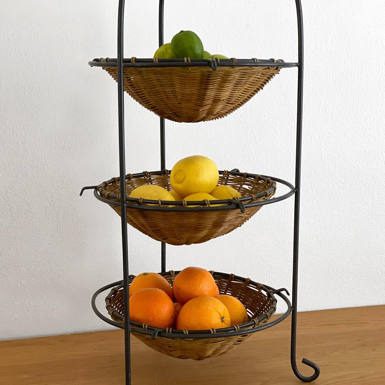 French wicker and iron tiered fruit stand
Consists of three floating baskets and iron frame 
Whimsical curved legs
Some wicker loss to areas below fruit storage
Lovely patina from age and use
Additional photos upon request.