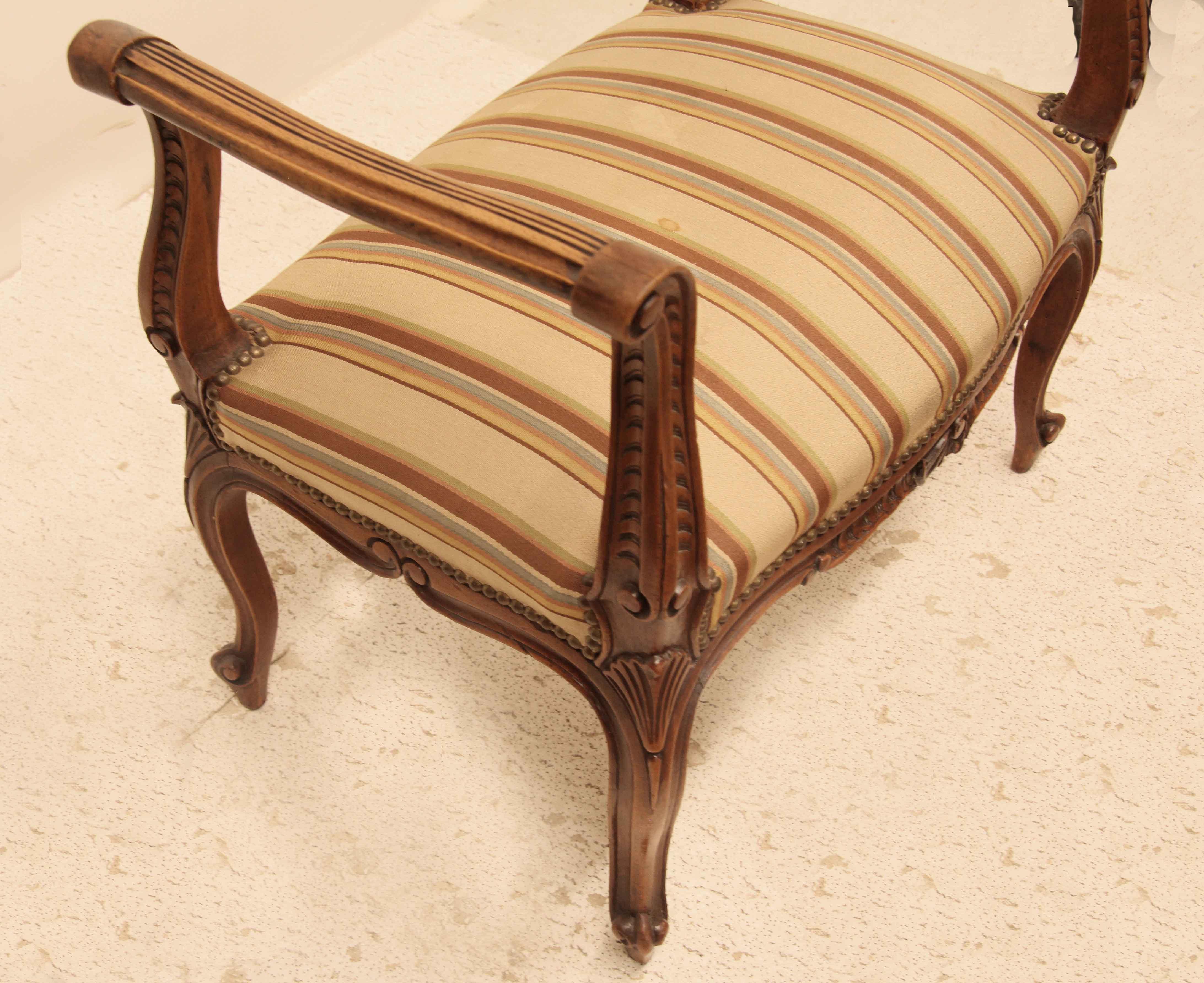 French upholstered window bench, this four sided bench has cabriole shaped arms with detailed carving , the serpentine apron and sides have similar carving ; cabriole legs with stylized shell on the knee tapering to a scrolled foot.  