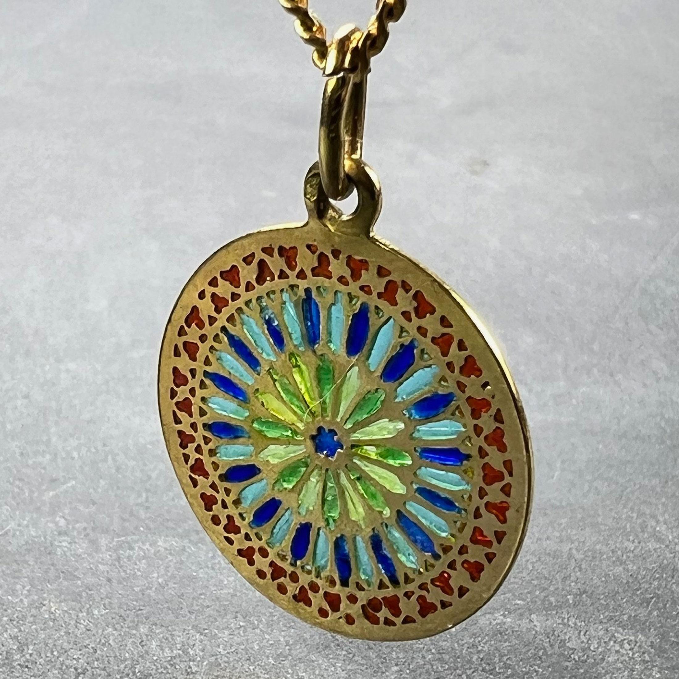 An 18 karat (18K) yellow gold charm pendant designed as a round medal depicting a stained glass window in plique-a-jour enamel. Stamped with the eagle's head mark for 18 karat gold and French manufacture.

Dimensions: 2.1 x 1.8 x 0.08 cm (not