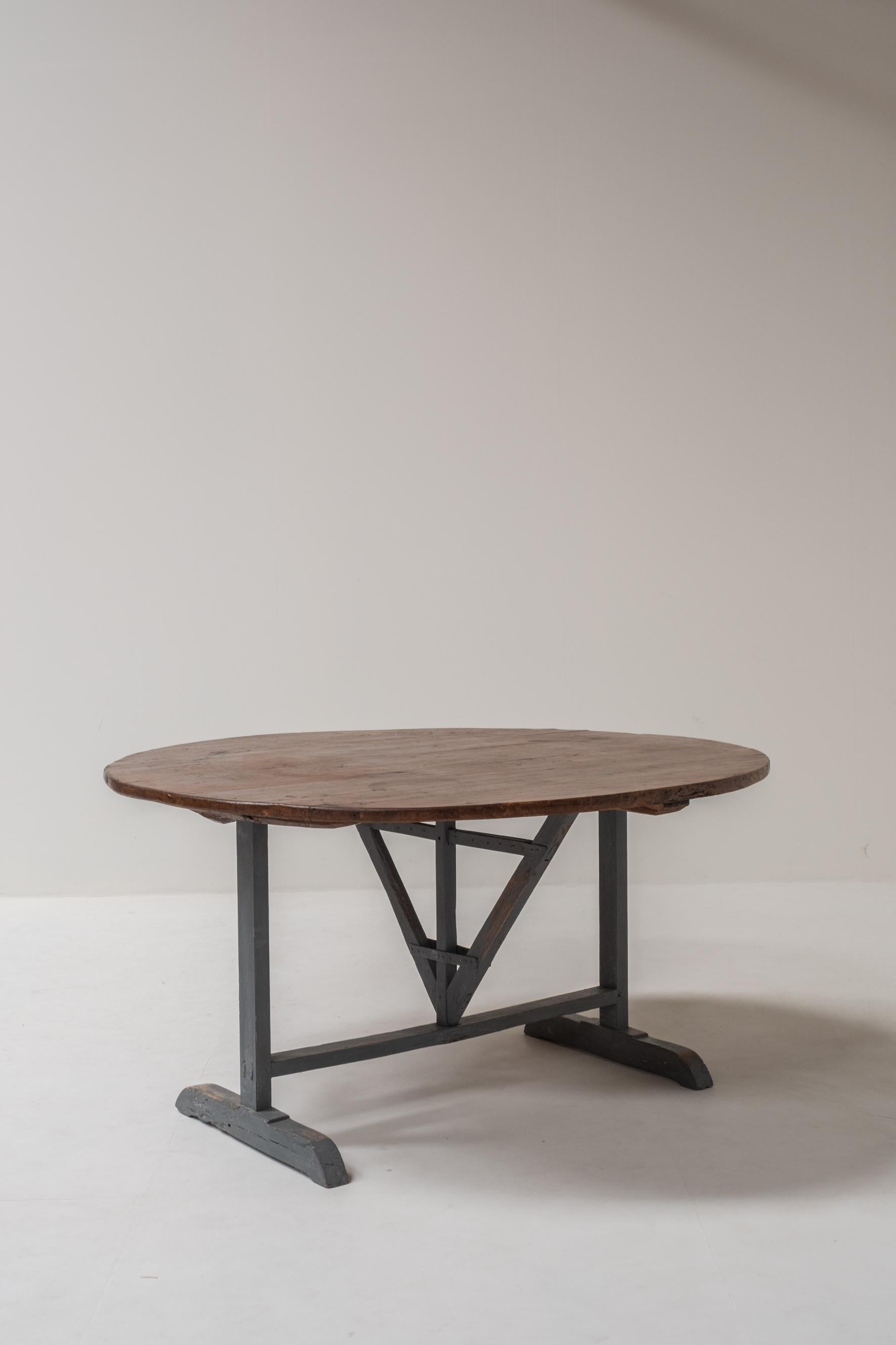 Beautiful round table crafted in solid wood, featuring a foldable top, typical of traditional French wine tasting tables. This exceptional piece stands out for its rare and generous size with 142 cm in diameter and 74 cm in height, making it ideal