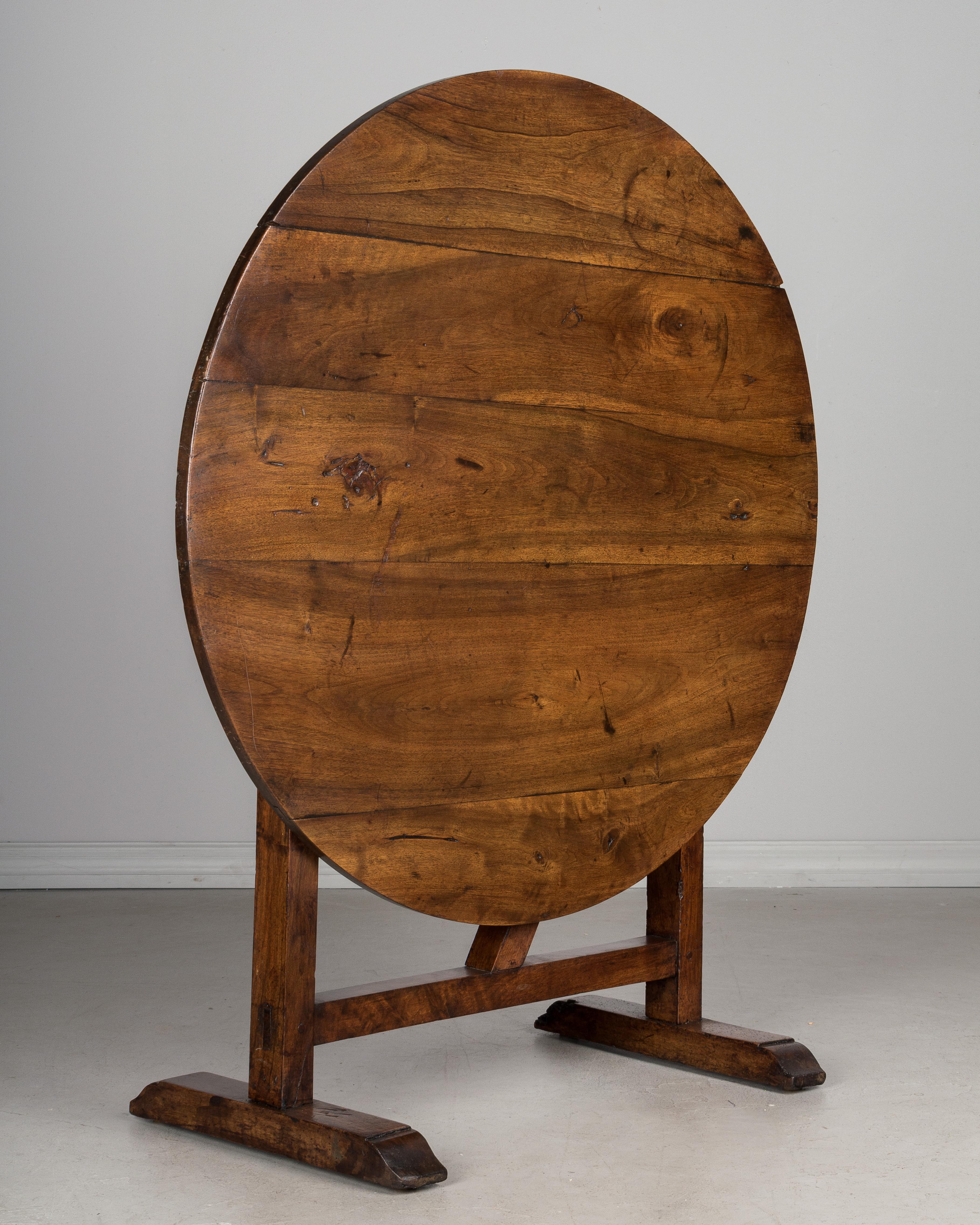A French wine tasting, or tilt-top table, made of solid walnut with old waxed patina. Well-crafted with mortise and tenon joints and pegged construction. The frame has been restored and the table is good and sturdy.
When the table is tilted the