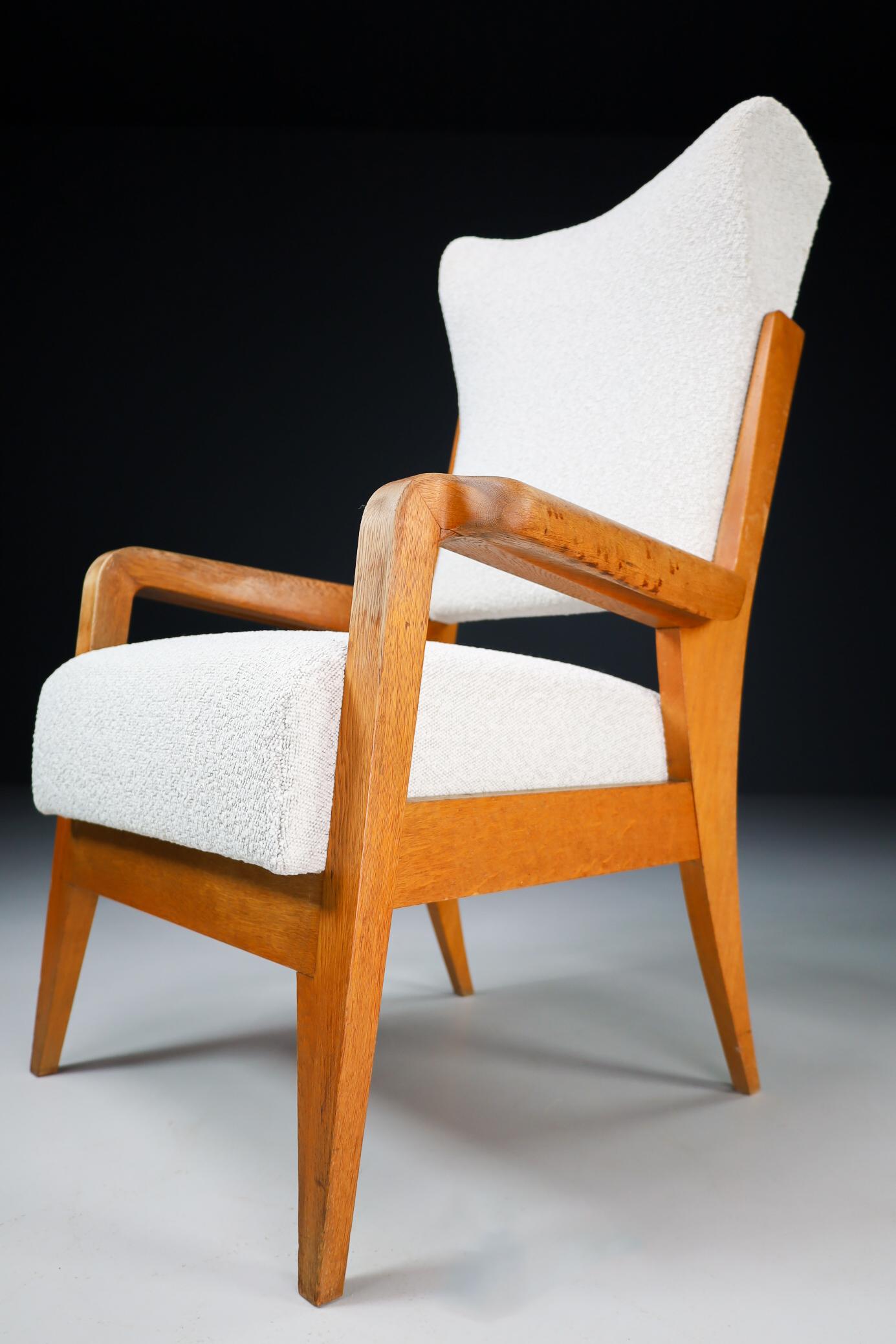 Wing armchair in patinated solid French oak and Re-upholstered Boucle wool fabric, France, 1950s. The grain of the wood is nicely visible and has an amazing good original patina. This chair would make an eye-catching addition to any interior such as