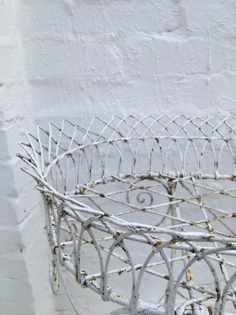 Beautiful weathered wire plant stand. The charm of this stand is in the signs of age. There are no breaks in the wire, but there are areas of paint loss and some light rust showing through as a consequence. We are loath to repaint it, in case this
