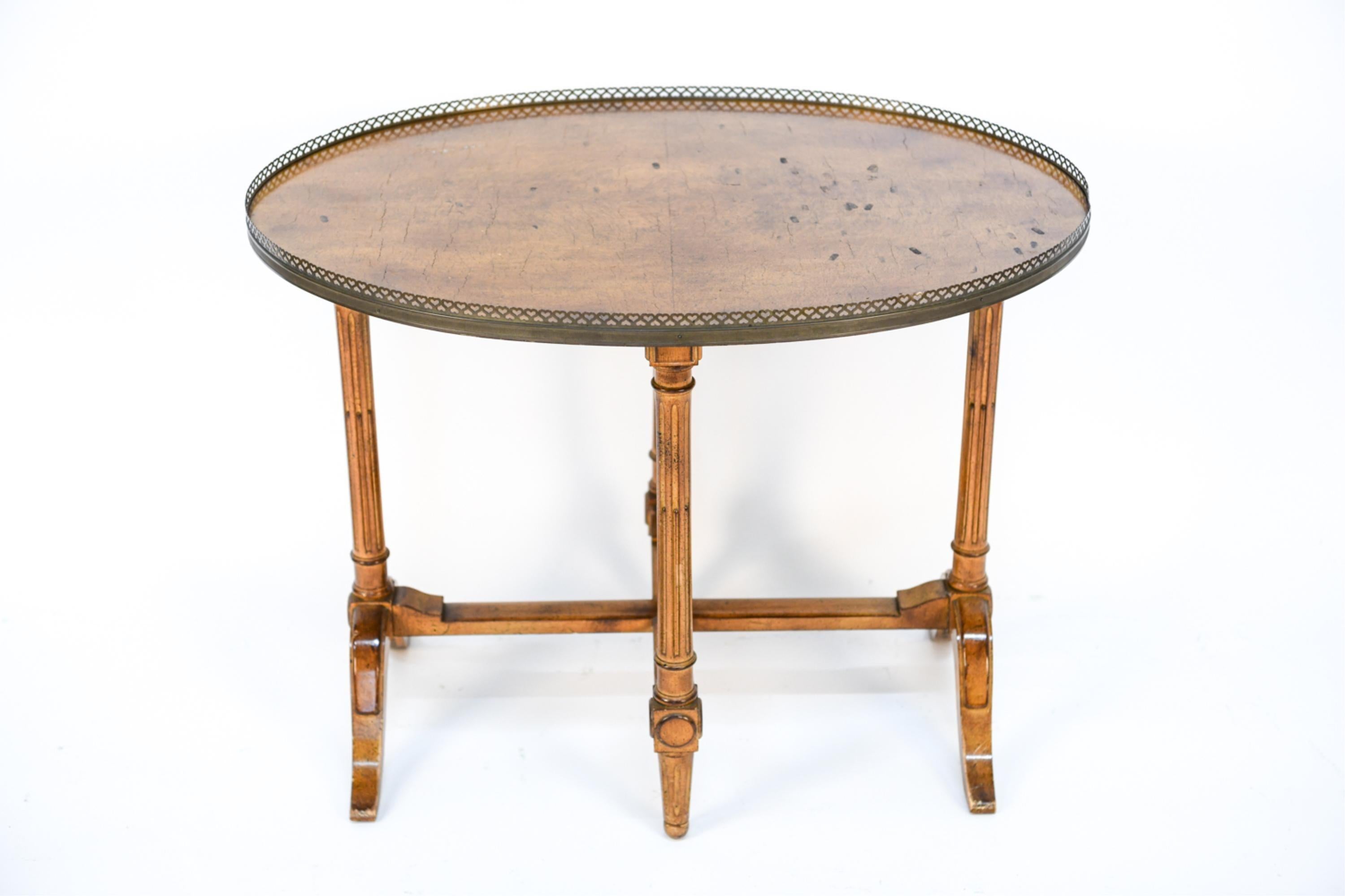 The stylish 19th century French table surrounded by a pierced brass gallery with elegantly carved trestled base legs with stretchers is the perfect size and height for an occasional tea table or distinct side or end table.
If you are in need of a