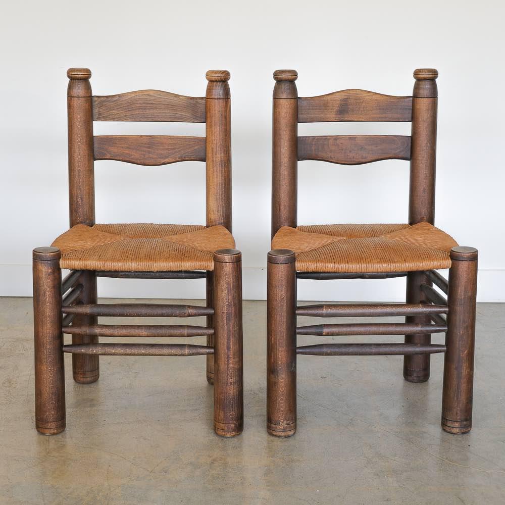 Incredible wood and woven chair by Charles Dudouyt from France 1940's. Solid and chunky tapered legs with beautiful wavy carved wood back. Newly replaced woven rush seat. Original dark wood stain is in vintage condition with some imperfections and
