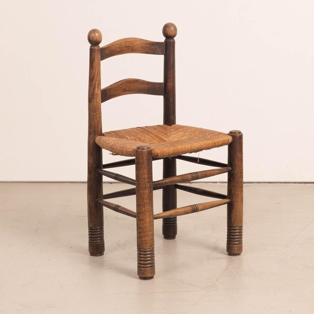 Incredible wood and woven chair by Charles Dudouyt from France 1950's. Solid and chunky tapered legs with beautiful wavy carved wood back and large wood ball details. Original woven rush seat in vintage condition with signs of wear. Dark wood frame