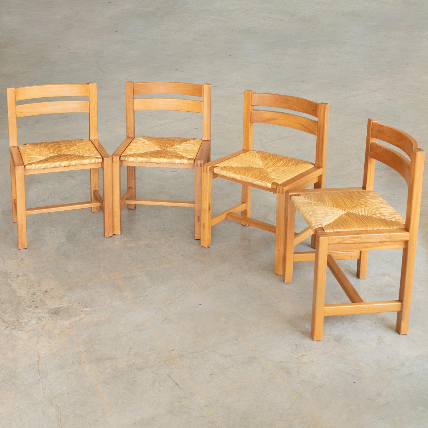 Incredible set of four elm and woven chairs by Maison Regain from France 1950s. Solid legs with beautiful curved wood backs. Original woven rush seats in great vintage condition. Wood is in vintage condition with some imperfections and age markings
