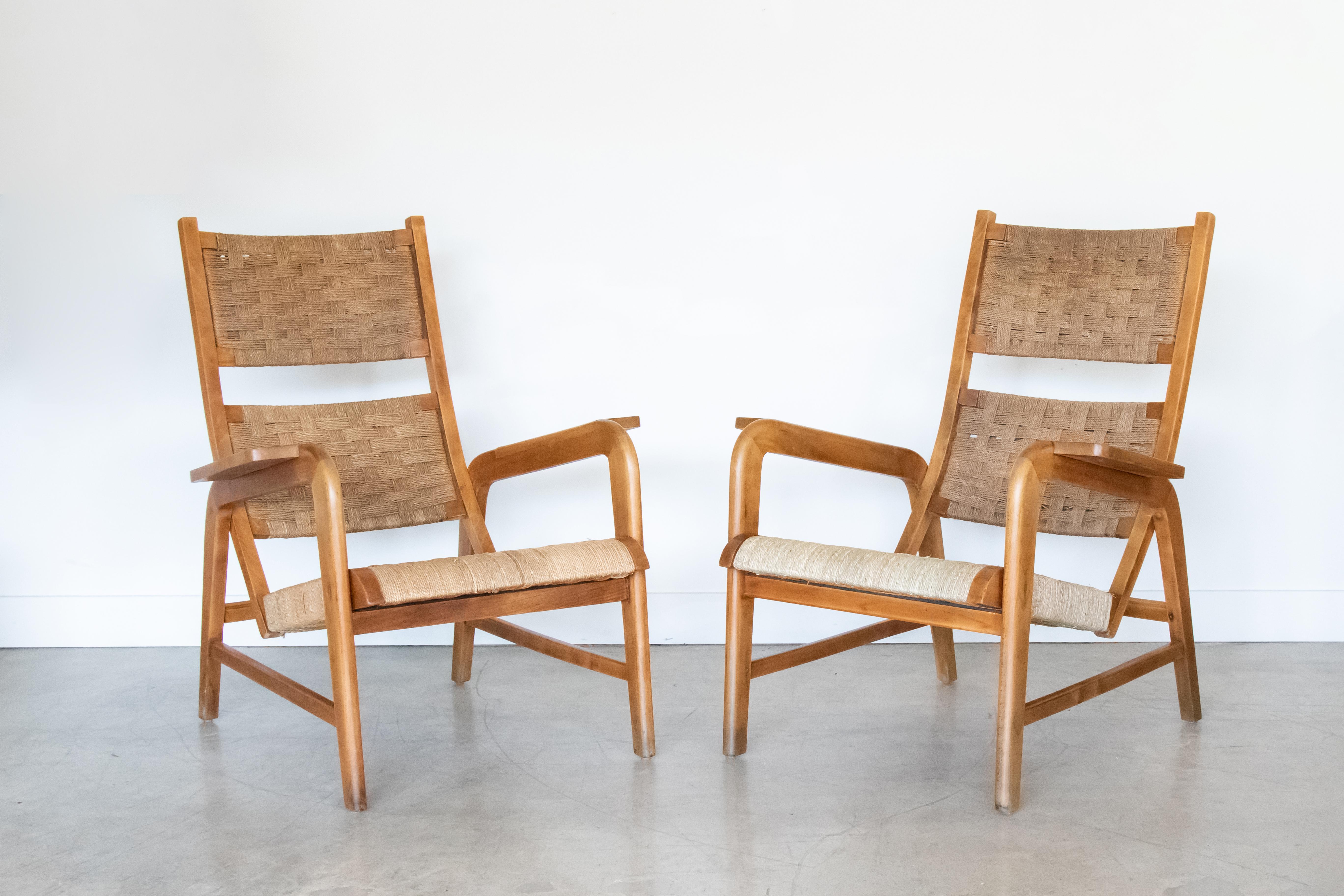 Pair of Italian wood lounge chairs with woven seagrass backs and seats. Beautiful angled legs and arms with high lounge backs. Elm wood frame has been freshly oiled and portions of the woven seagrass have been replaced.