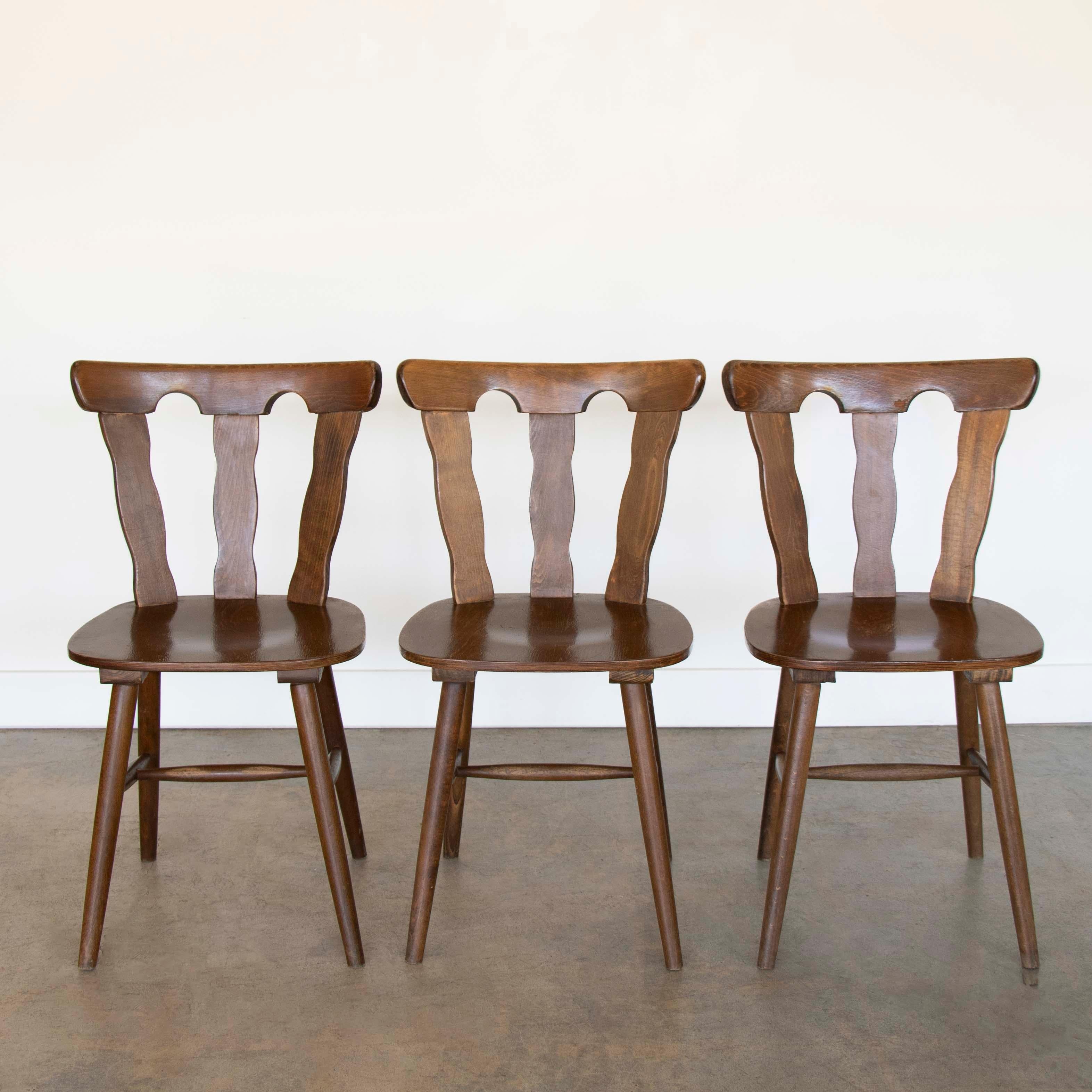 Great wood mountain chairs from France, 1950's. Brutalist style with carved wood back with three wide slates. Formed wood seat rests on four tapered wood legs. Original dark wood finish is in vintage condition with some imperfections and age