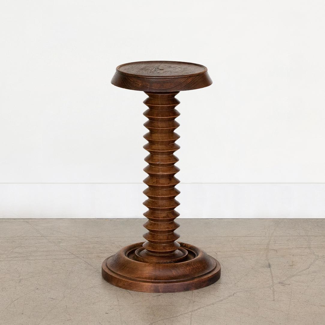 Beautiful small carved wood drink table in the style of Charles Dudouyt, made in France, 1940's. Thick carved wood stem with circular top and base. Original wood finish showing nice age markings and patina. Wood top has small center hole. Perfect