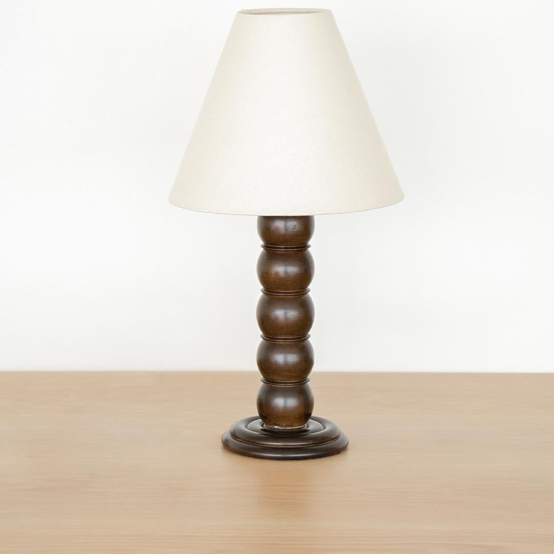 Vintage wood table lamp from France, 1940s. Stacked ball forms with circular base and newly refinished. New cream linen tapered shade and newly re-wired.

Measures: Shade diameter 10