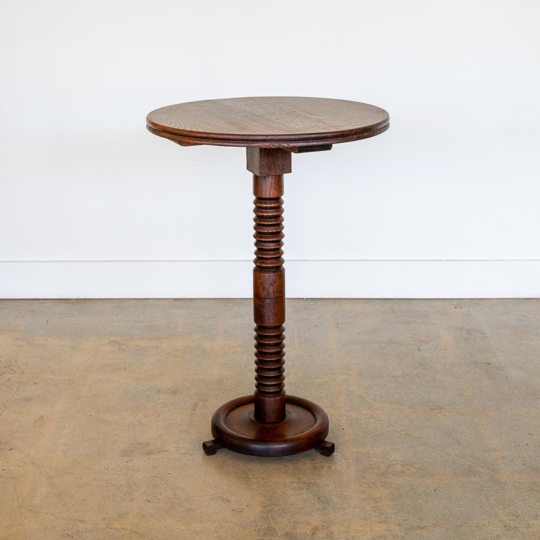 Beautiful carved wood table by Charles Dudouyt, made in France, 1940's. Carved wood stem with circular top and base and three small carved wood feet. Original finish shows great age and patina. Perfect between two chairs. 