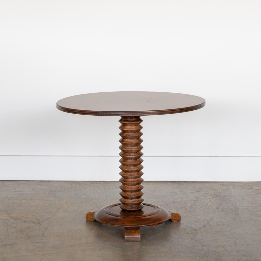 Great carved wood table by Charles Dudouyt, made in France, 1940's. Thick carved wood stem with circular top and base with 3 carved feet. Newly refinished medium wood stain. Perfect drink table next to a chair.  