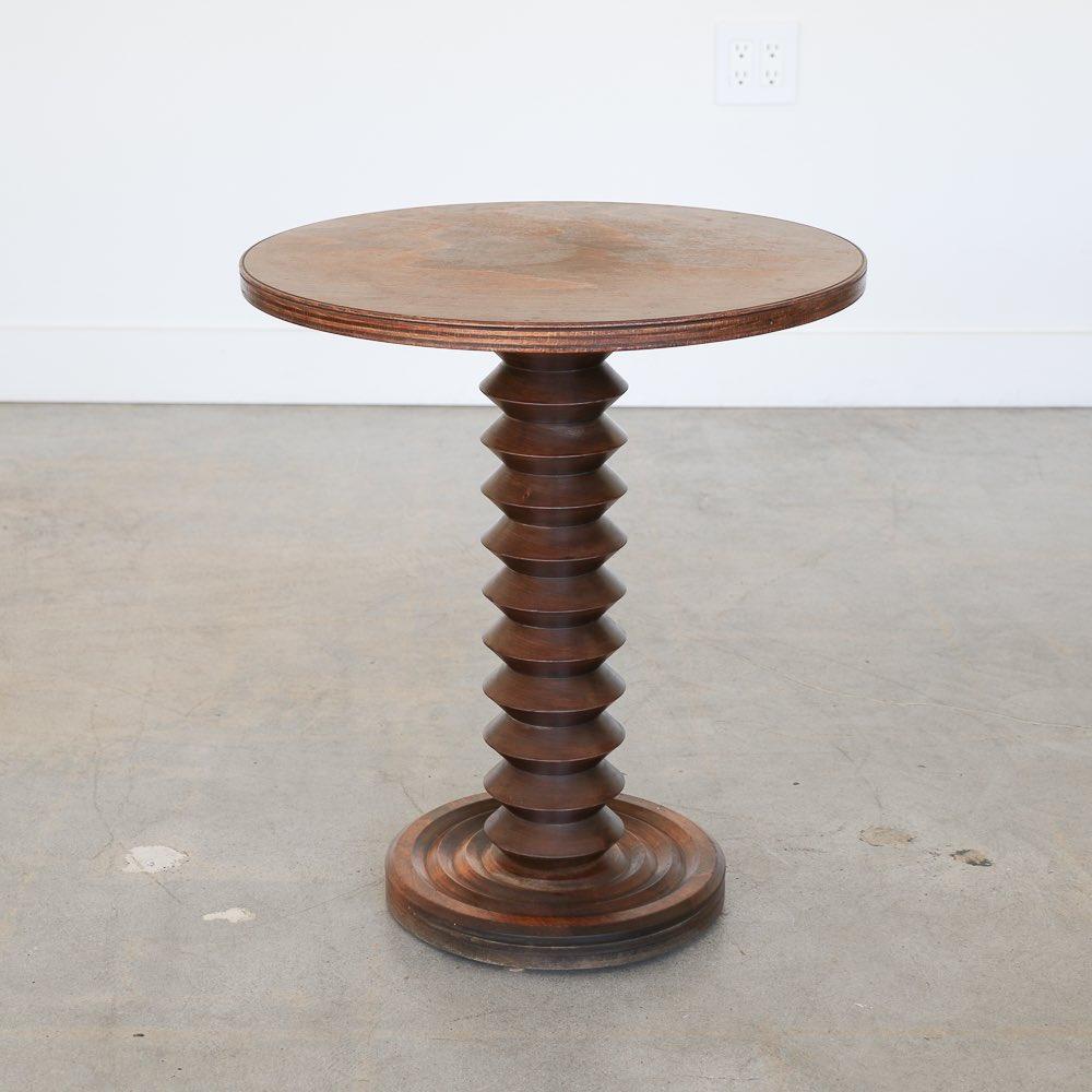 Superbe table en bois sculpté de Charles Dudouyt, fabriquée en France dans les années 1940. Tige épaisse en bois sculpté avec plateau et base circulaires. La finition d'origine est très ancienne et patinée. Parfait entre deux chaises. 
