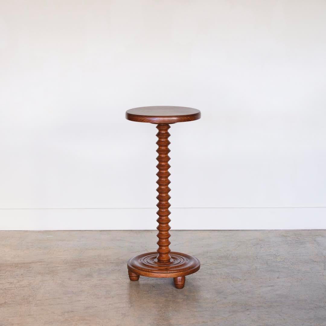 Beautiful carved oak side table by Charles Dudouyt, made in France, 1940's. Thick carved wood stem with circular top and three wood ball feet on circular base. Newly refinished medium oak stain.