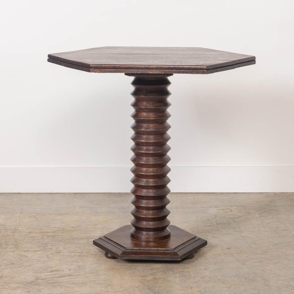 Grande tavolo in legno intagliato di Charles Dudouyt dalla Francia, anni '40. Gambo in legno intagliato di grande spessore con piano e base esagonali. La base poggia su tre piedi arrotondati. La finitura originale del legno mostra un'ottima età e
