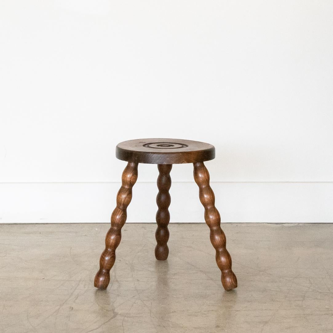 Vintage wood stool with beautiful wavy wood legs from France. Circular seat with unique carved ring detail on top. Original wood finish with great age markings and patina. Can be used as small stool or as side table next to chairs. 

 