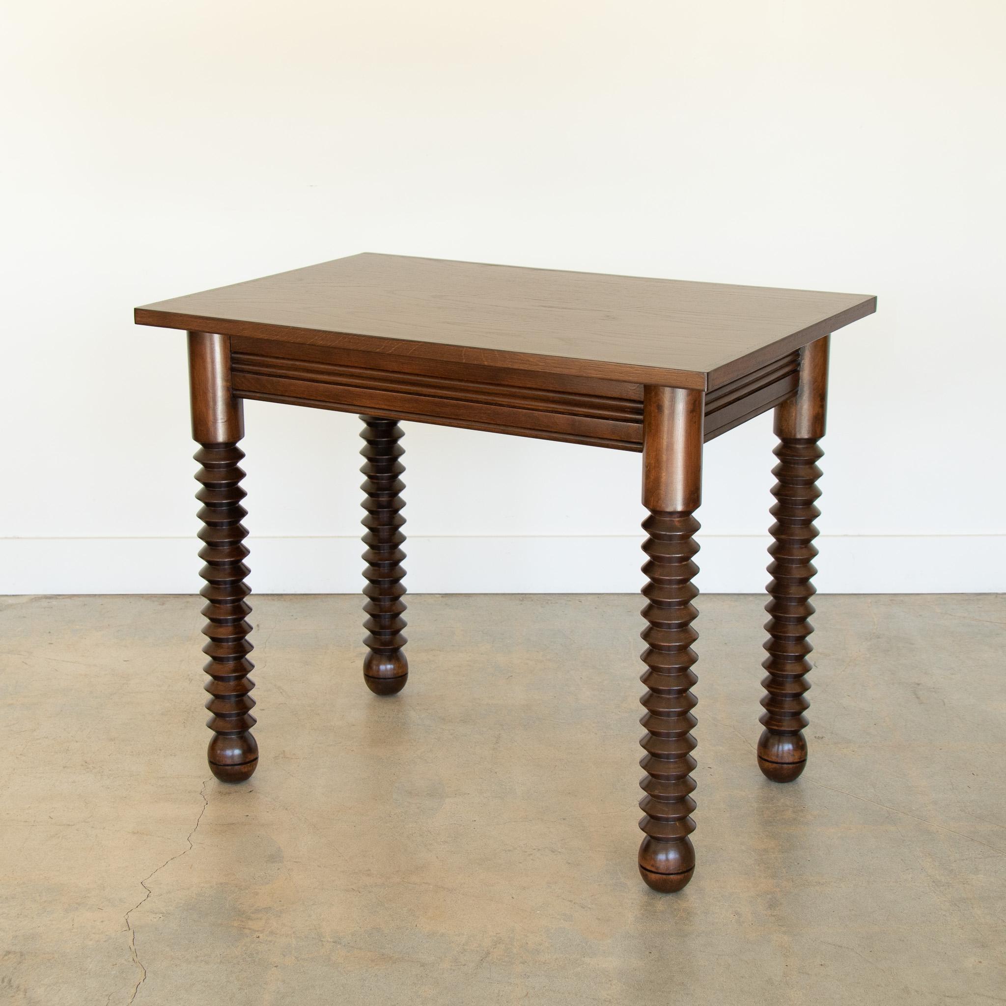 Superbe table en bois de Charles Dudouyt, fabriquée en France dans les années 1940.  Plateau rectangulaire avec quatre épais pieds en bois sculpté et pieds boules. Nouvellement rénové avec une teinture moyenne montrant le grain du bois. Parfait pour