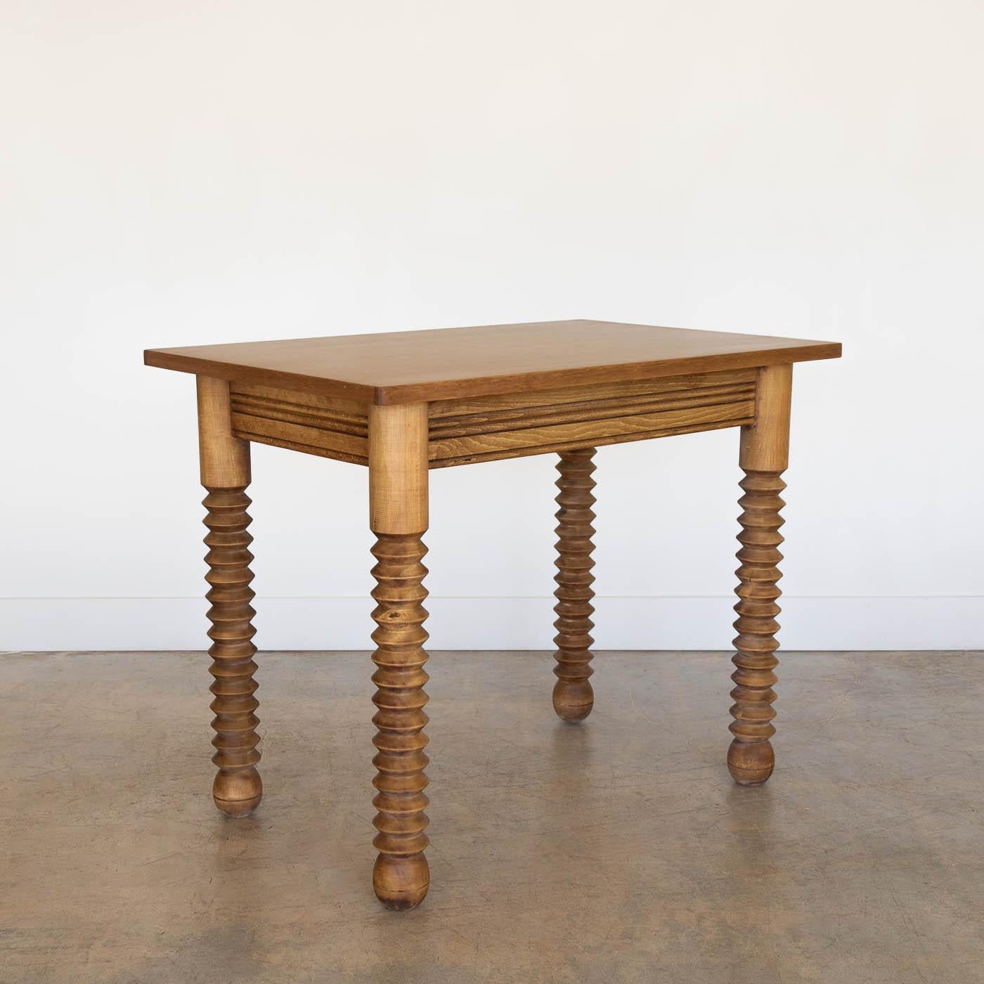 Great wood table by Charles Dudouyt, made in France, 1940's.  Rectangular top with four thick carved wood legs and ball feet. Newly refinished in light stain showing nice grain in wood and newly replaced veneer top. Perfect as a small desk or