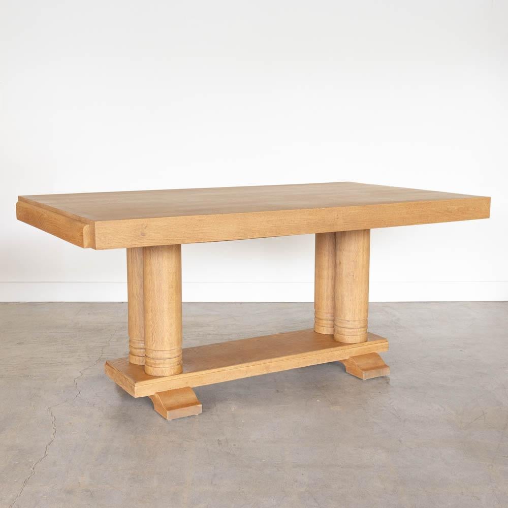Incroyable table en bois de Charles Dudouyt, fabriquée en France dans les années 1940. Grand plateau rectangulaire en parquet avec quatre épais pieds en bois sculpté sur un socle. Nouvellement rénové dans une teinture claire montrant un magnifique