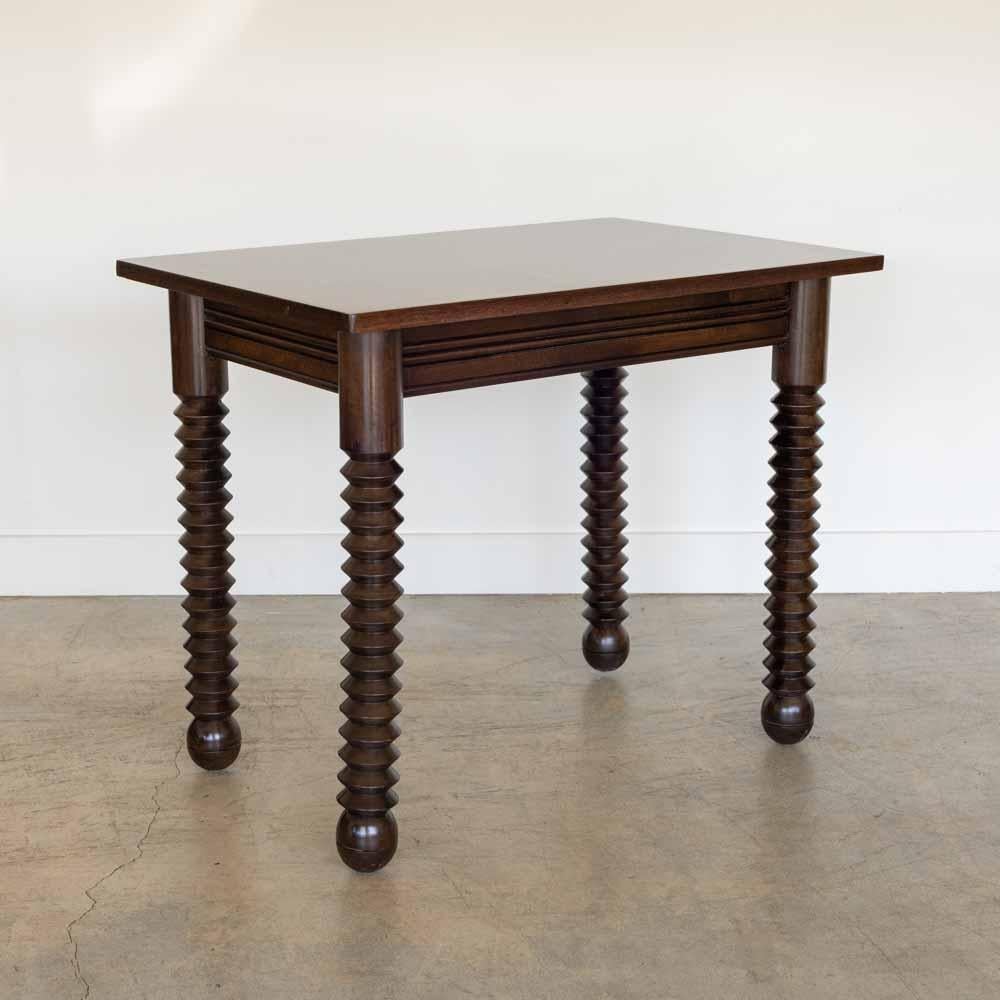 Great wood table by Charles Dudouyt, made in France, 1940's.  Rectangular top with four thick carved wood legs and ball feet. Newly refinished in dark stain showing nice grain in wood and newly replaced veneer top. Perfect as a small desk or console