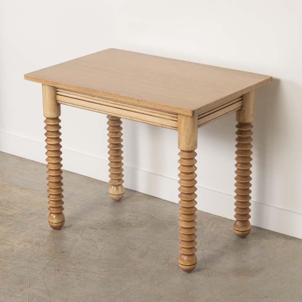 Incredible wood table by Charles Dudouyt, made in France, 1940's.  Rectangular top with four thick carved wood legs and ball feet. Newly refinished in light stain showing nice grain in wood and newly replaced oak veneer top. Perfect as a small desk