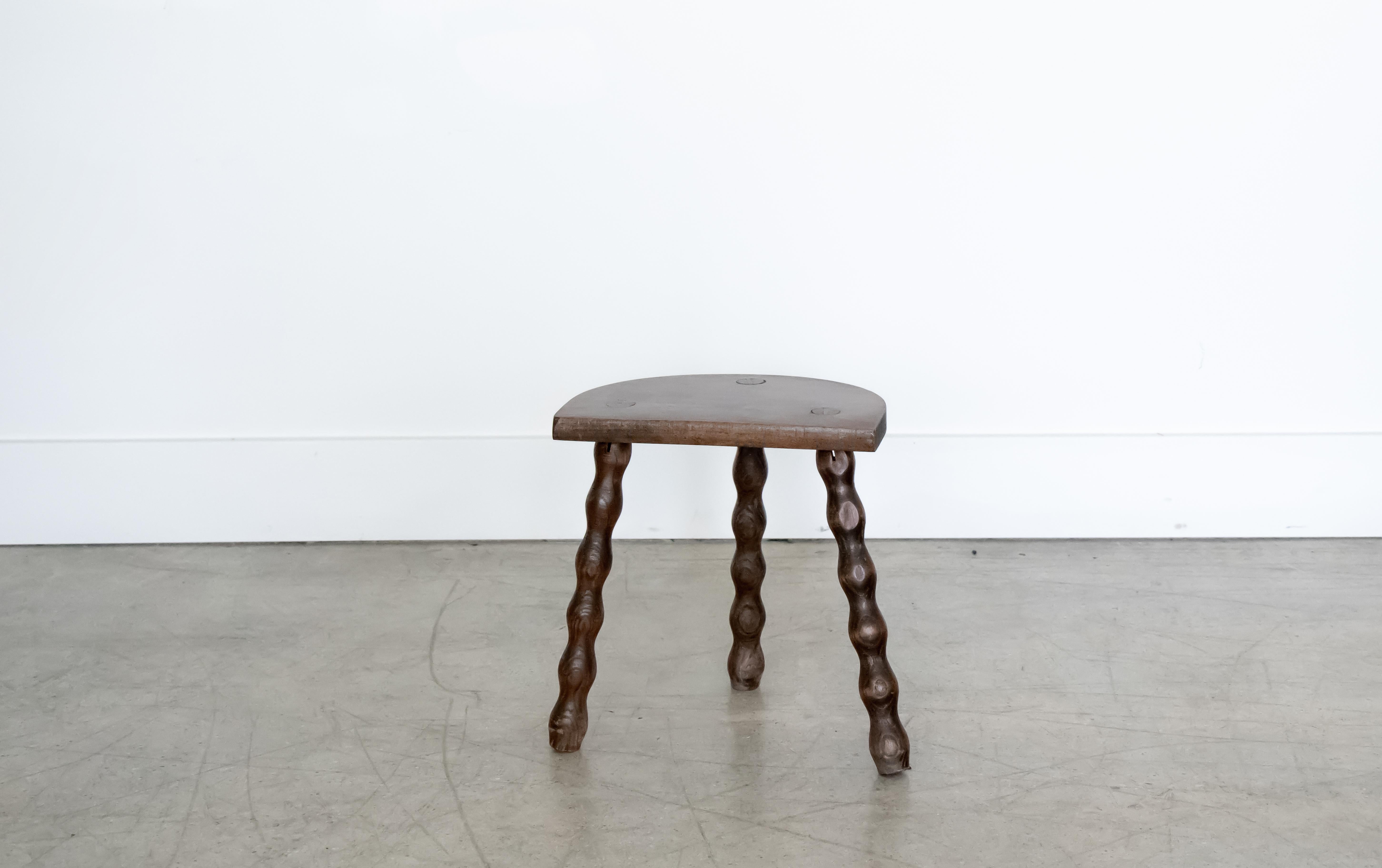 Vintage wood stool with beautiful wavy tripod legs from France. Original dark wood finish with great age markings and patina. Can be used as a small stool or as side table next to chairs. 

 