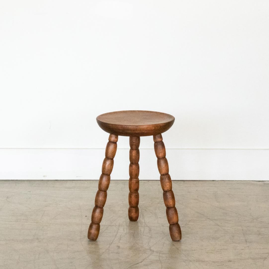 Vintage wood tripod stool with beautiful bobbin legs from France. Circular seat with original wood finish showing great age markings and patina. Can be used as small stool or as side table next to chairs. 



 