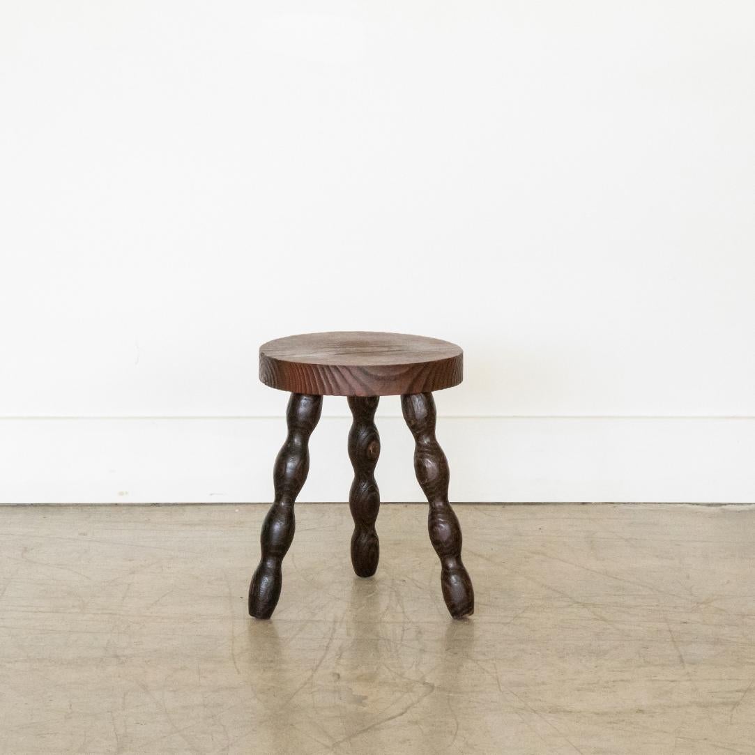 Vintage wood tripod stool with wavy legs and thick circular seat from France. Original dark wood finish showing great age markings and patina. Can be used as small stool or as side table next to chairs. 



 