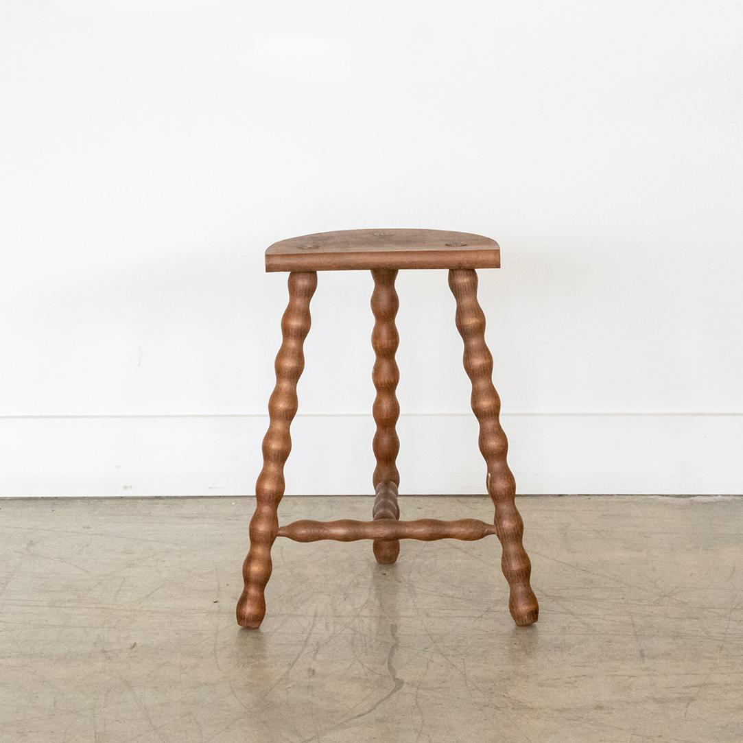 Vintage tall wood stool with semi-circle seat and wavy tripod legs from France. Original wood finish with great age markings and patina. Can be used as a stool or as side table. 



