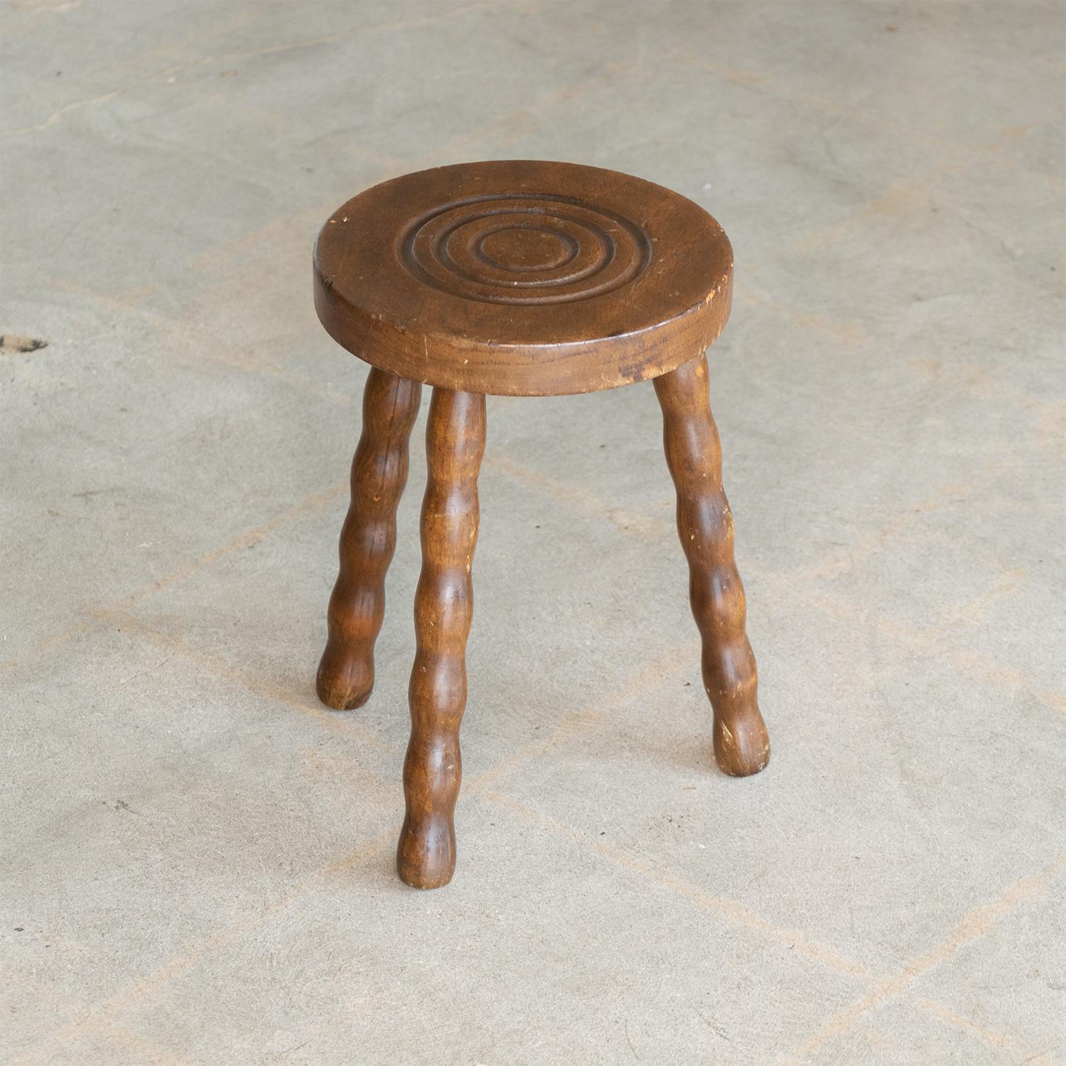 Great vintage wood tripod stool from France, 1950s. Circular top with carved ring detail and three wavy wood leg base. Original condition shows signs of wear, age, and knicks in wood. Perfect as small table next to chair or bathtub.



.
