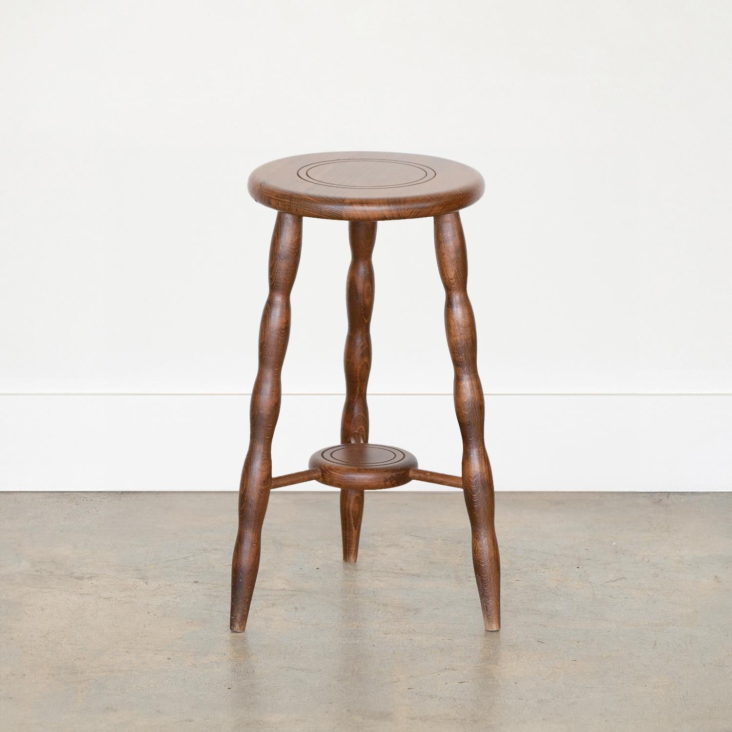 Great vintage wood tripod stool from France, 1950s. Circular top with carved ring detail and three wavy wood leg base with a lower wood disc. Original condition shows signs of wear, age, and knicks in wood. Perfect as small table next to chair or