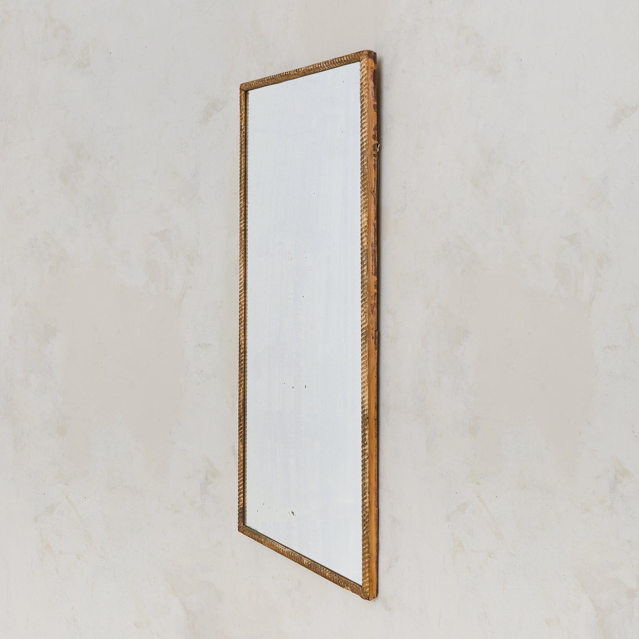 Un grand miroir mural français datant du 19ème siècle. Le cadre rectangulaire en bois sculpté à la main est enveloppé de plâtre moulé à la main, sculpté en relief à l'aide d'une corde et terminé par une dorure usée par le temps. Les fissures, les