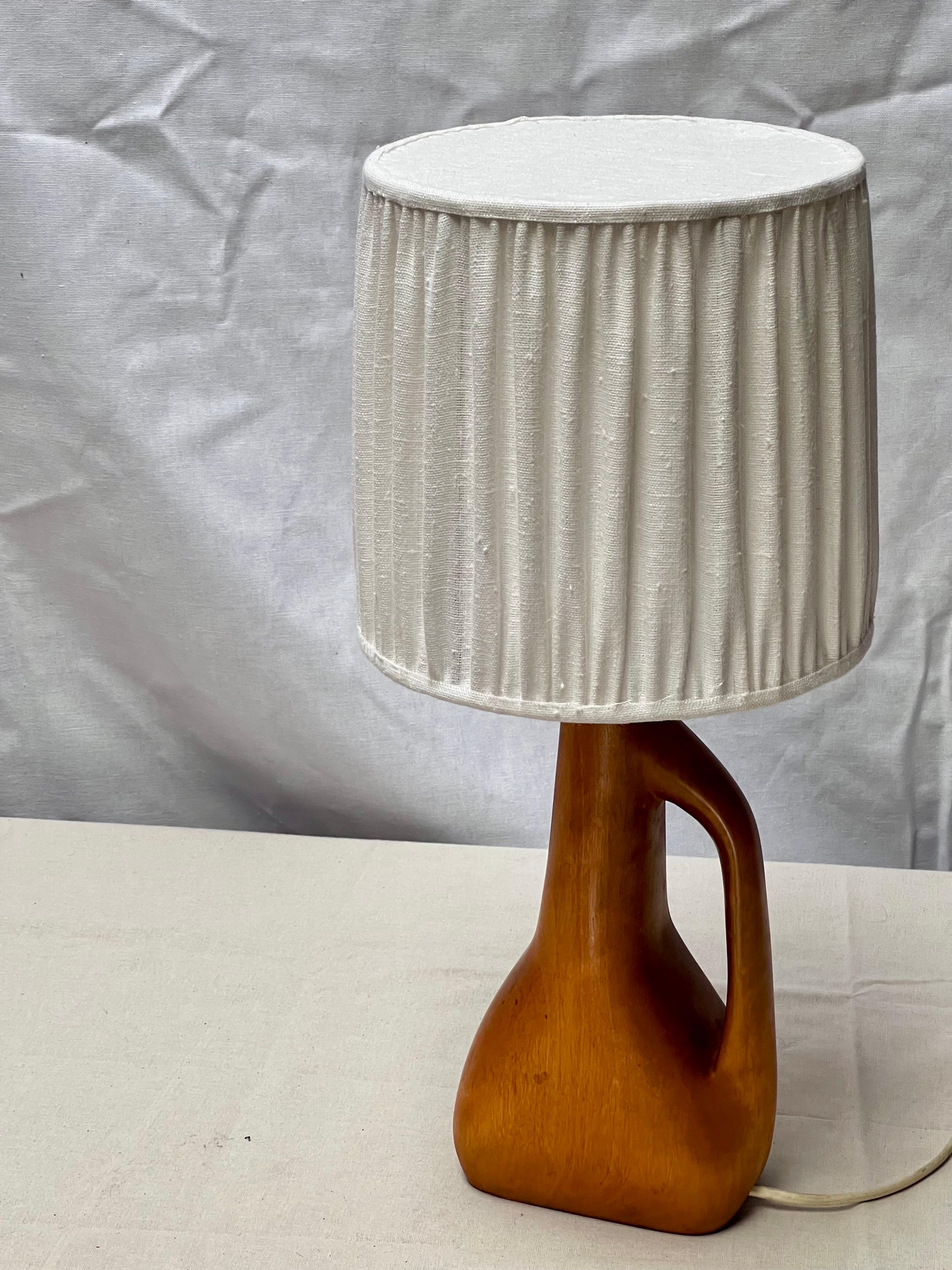 Lampe décorative en bois dur fabriquée en France dans les années 1940 / 1950. Fabriqué en bois dur, il a la forme sculpturale d'une cruche. La hauteur totale de cette lampe, abat-jour compris, est de 50 cm. L'abat-jour a une hauteur de 23 cm et un