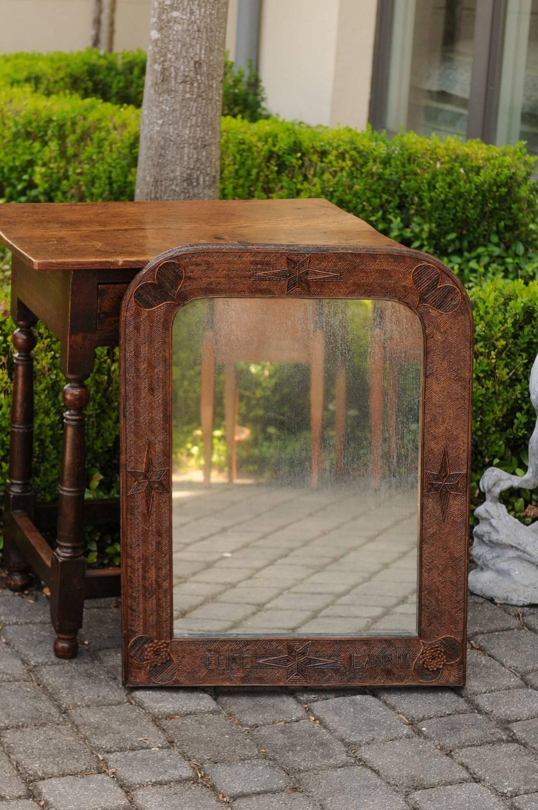 A French Folk Art mirror from the early 20th century, with heart and star motifs. This French Folk Art mirror features an elegant Louis-Philippe inspired Silhouette, recognizable by its linear frame topped with rounded corners. While Louis-Philippe