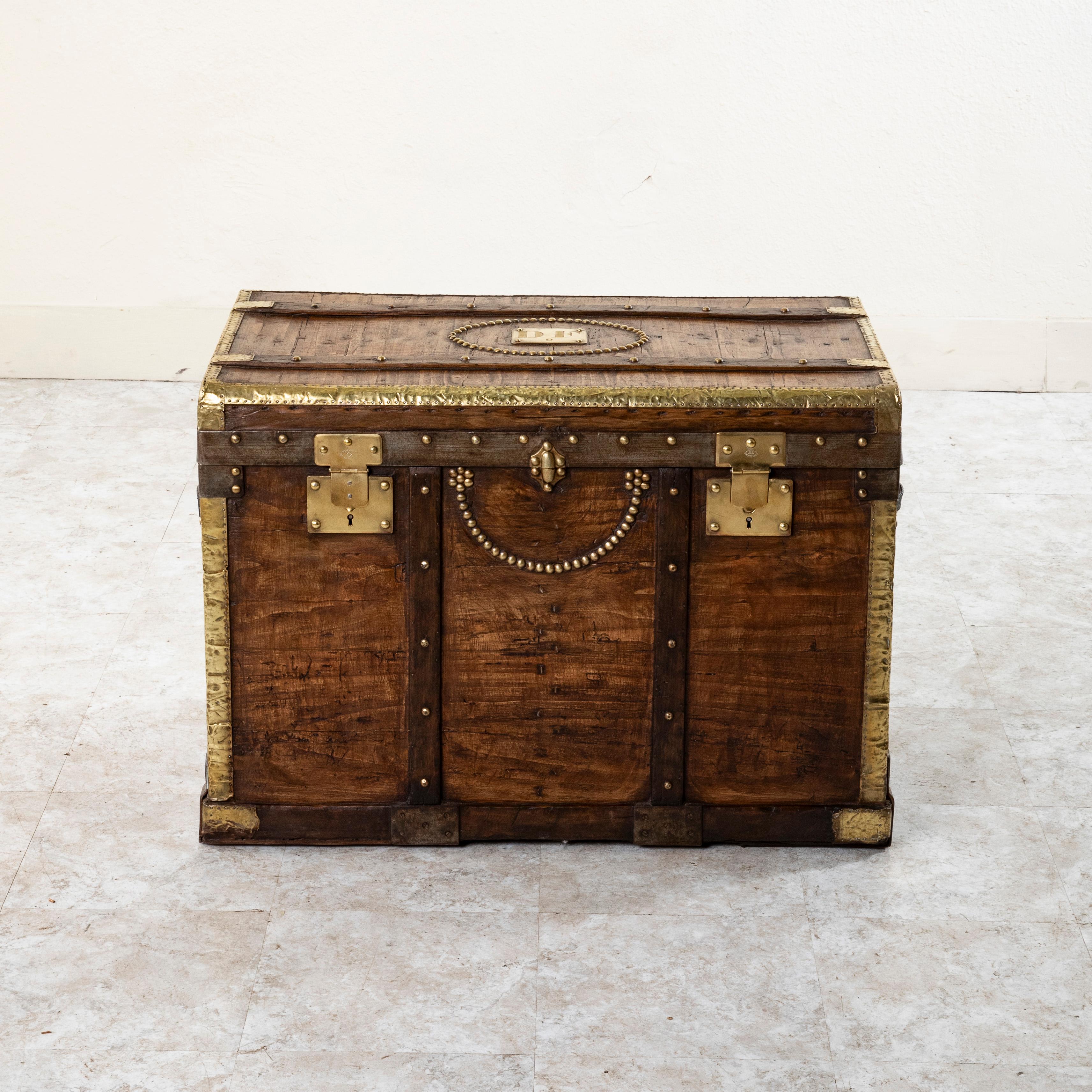 This wooden steam trunk from the late nineteenth century features locks stamped Depose, or trademarked, as well as a brass plaque on the top marked with initials DF and the number 2. Its wooden runners with brass rivets and brass corners offered